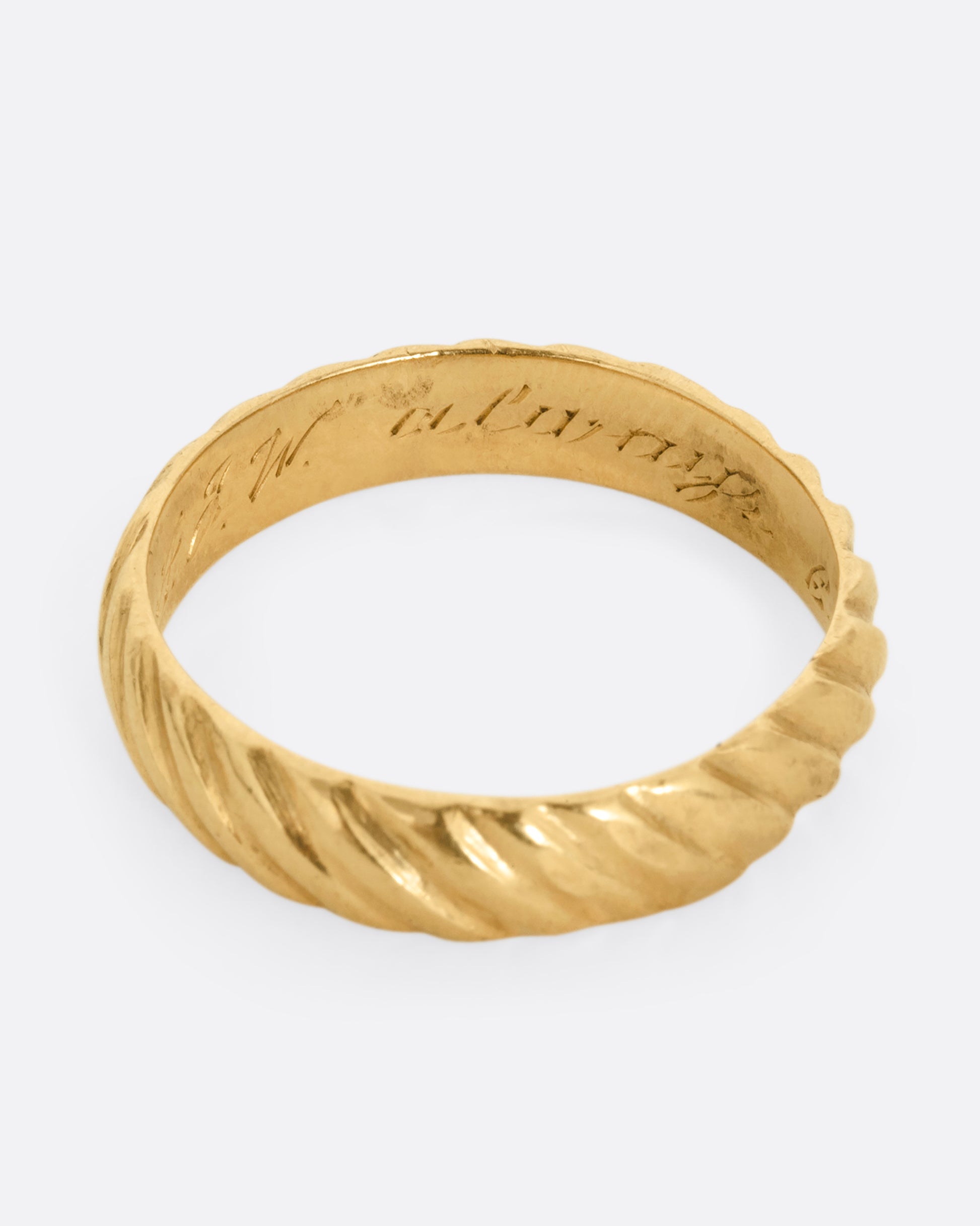 A yellow gold band with a continuous diagonal pattern. Shown from the top.