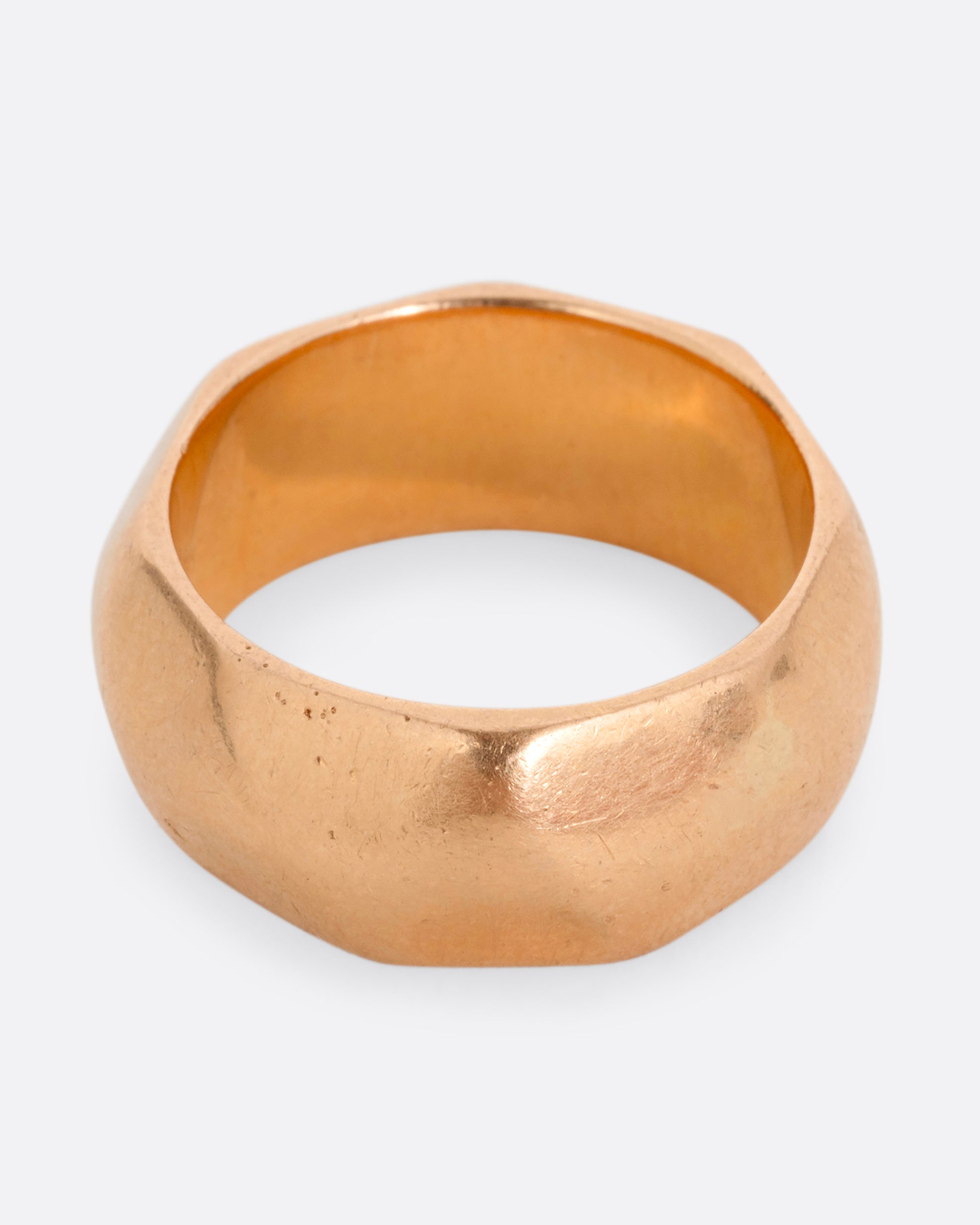A wide hammered yellow gold cigar band. Shown from the front.