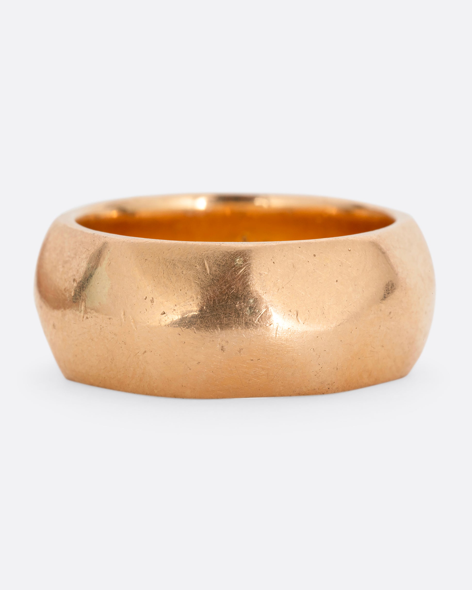 A wide hammered yellow gold cigar band. Shown from the front.