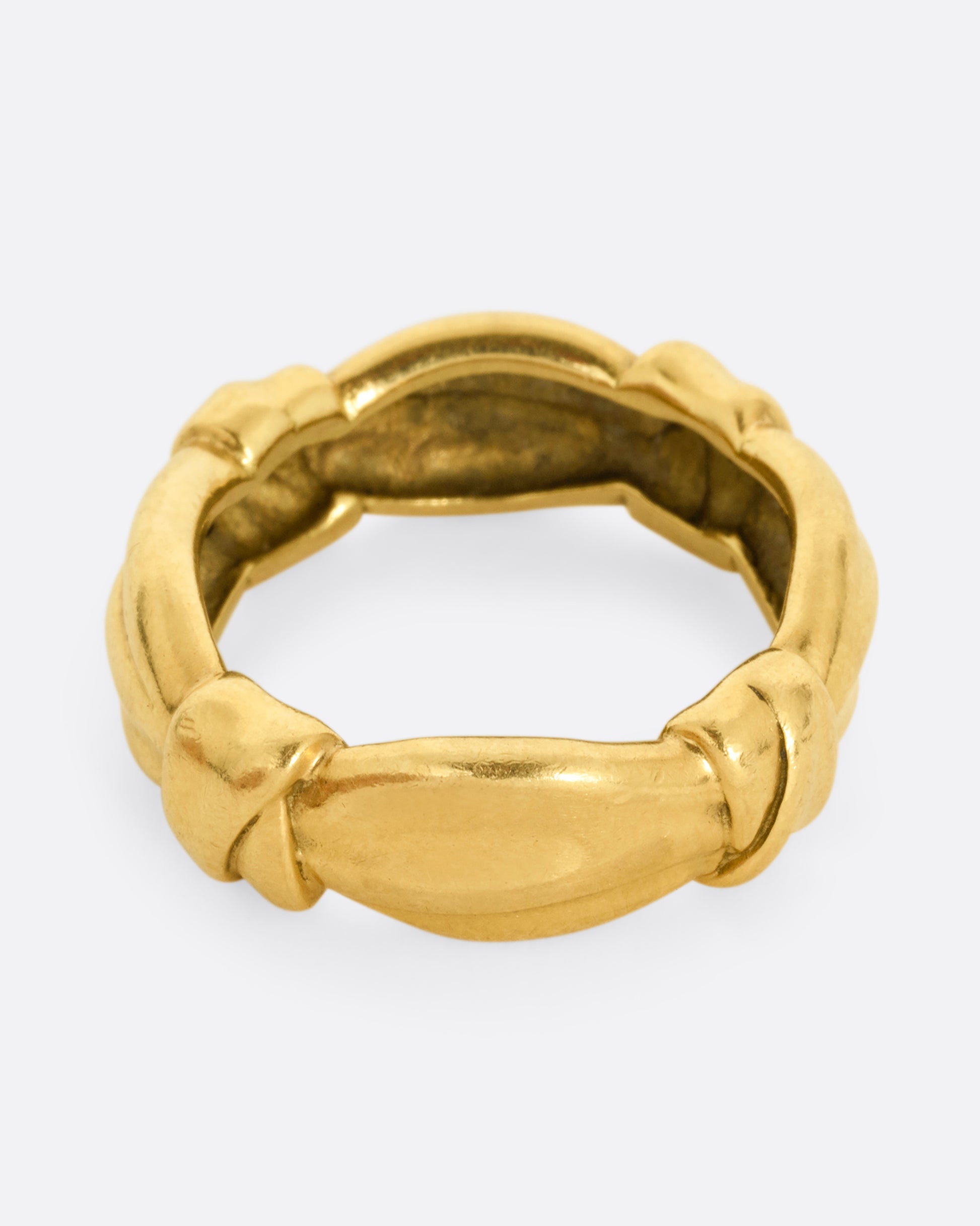 A yellow gold ring with bow knots throughout. Shown from the top.
