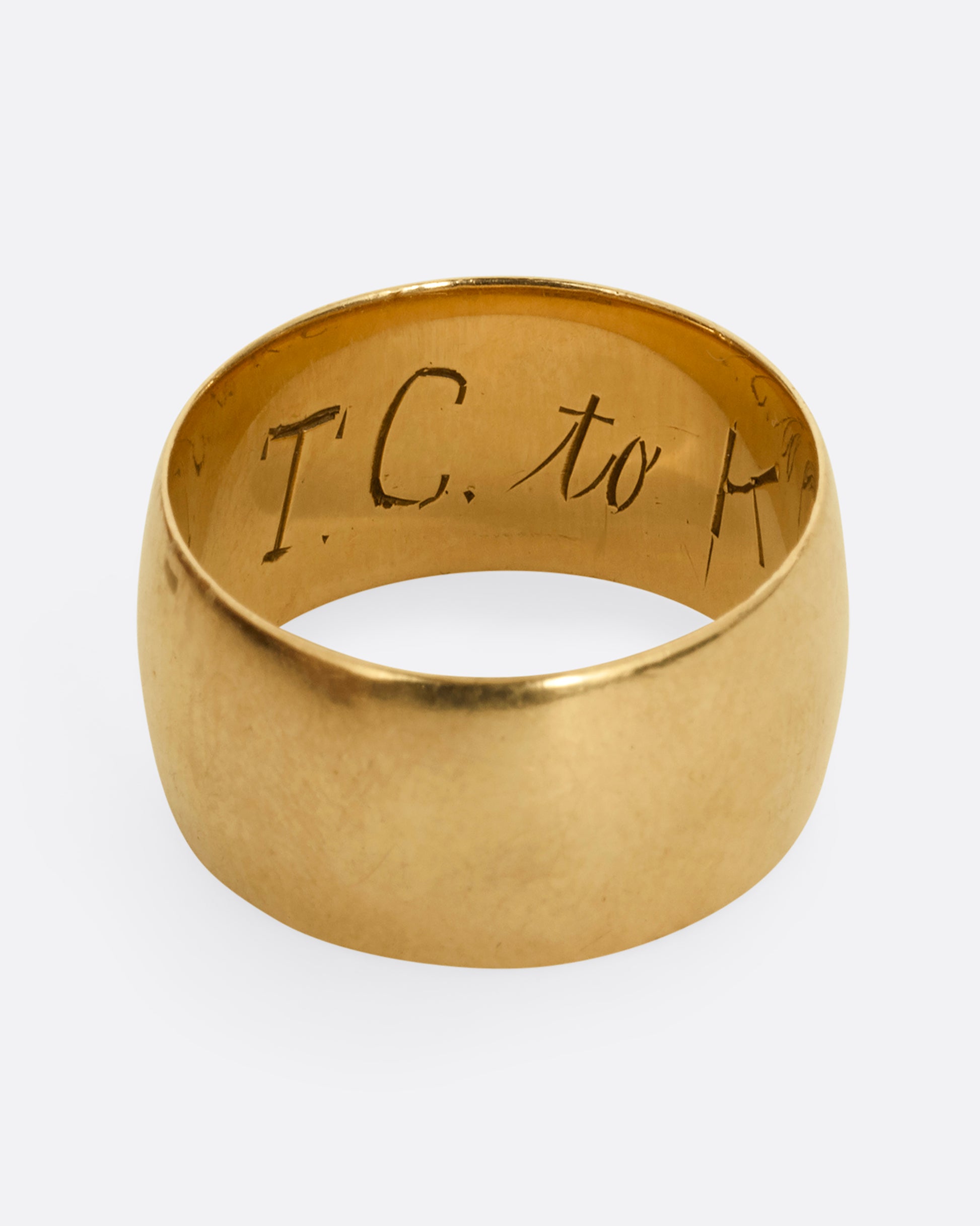 A thick yellow gold cigar band with T.C. to K engraved on the inside. Shown from the top.