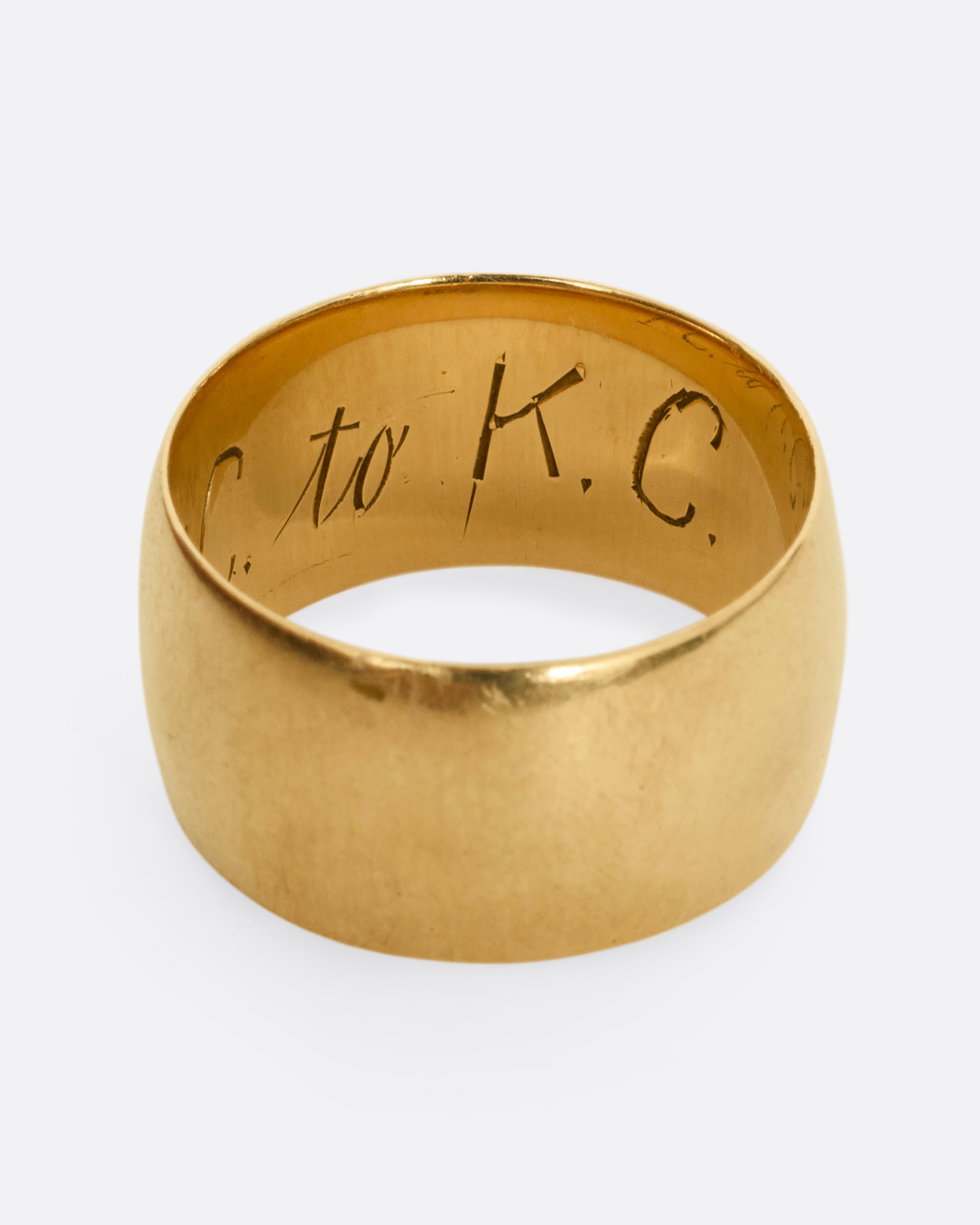 A thick yellow gold cigar band with T.C. to K.C. engraved on the inside. Shown from the top.