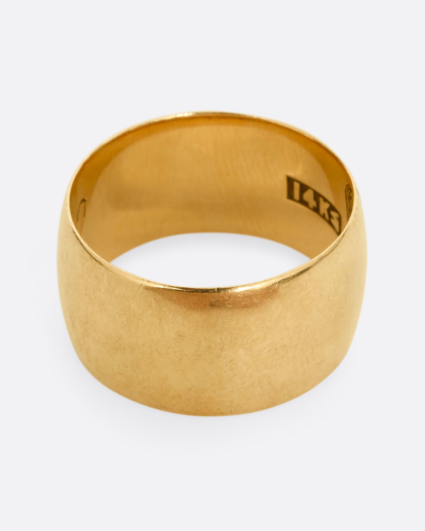 A thick yellow gold cigar band with T.C. to K engraved on the inside. Shown from the front.