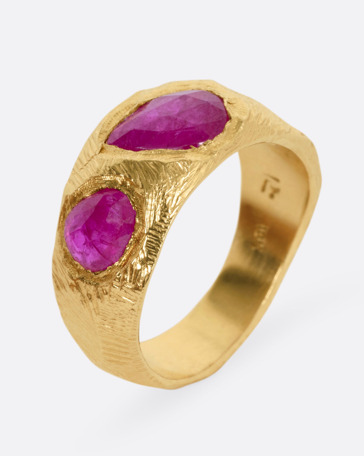A yellow gold ring with three rubies, shown from the side standing up.