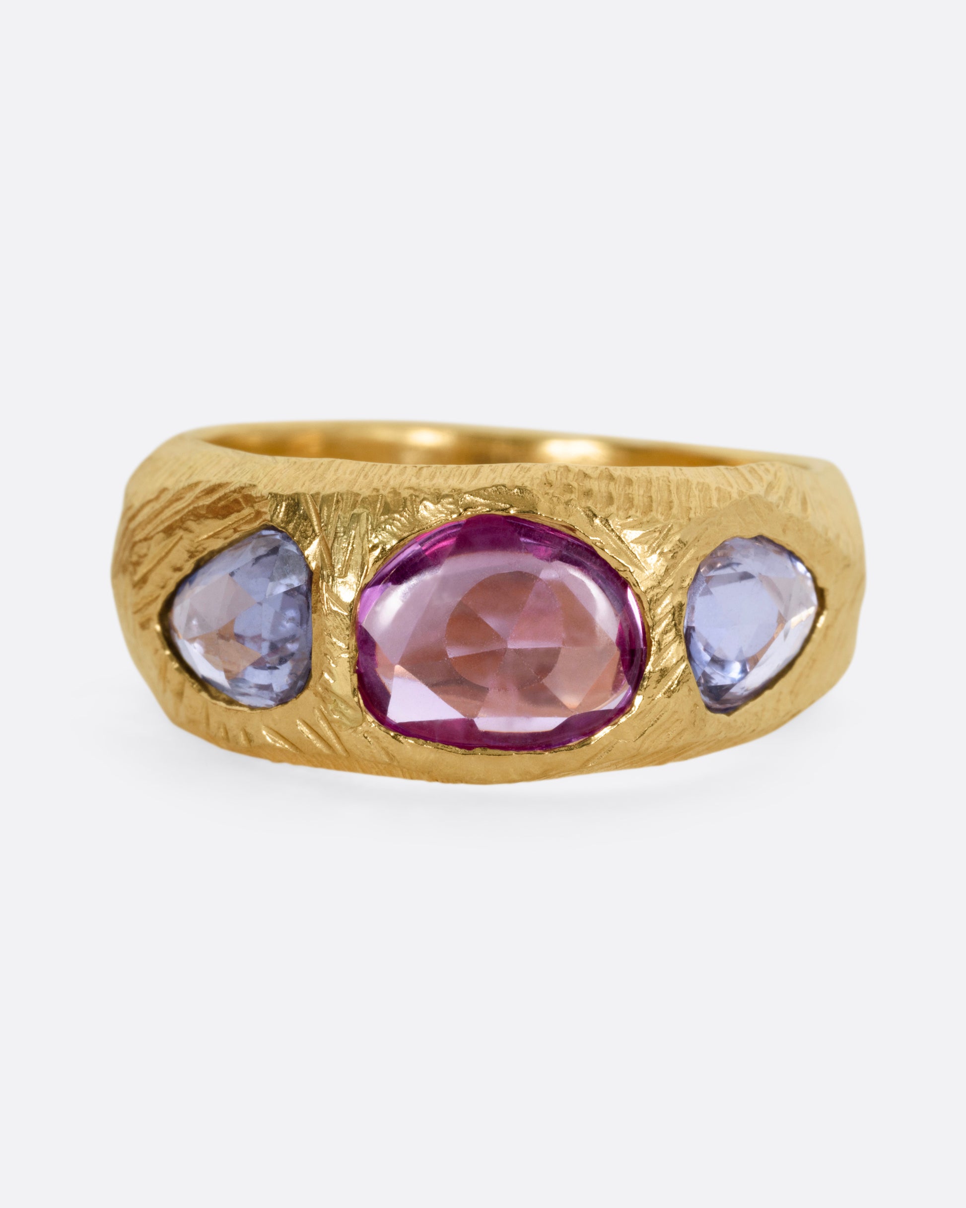 A yellow gold ring with two blue sapphires and one pink, shown from the front.