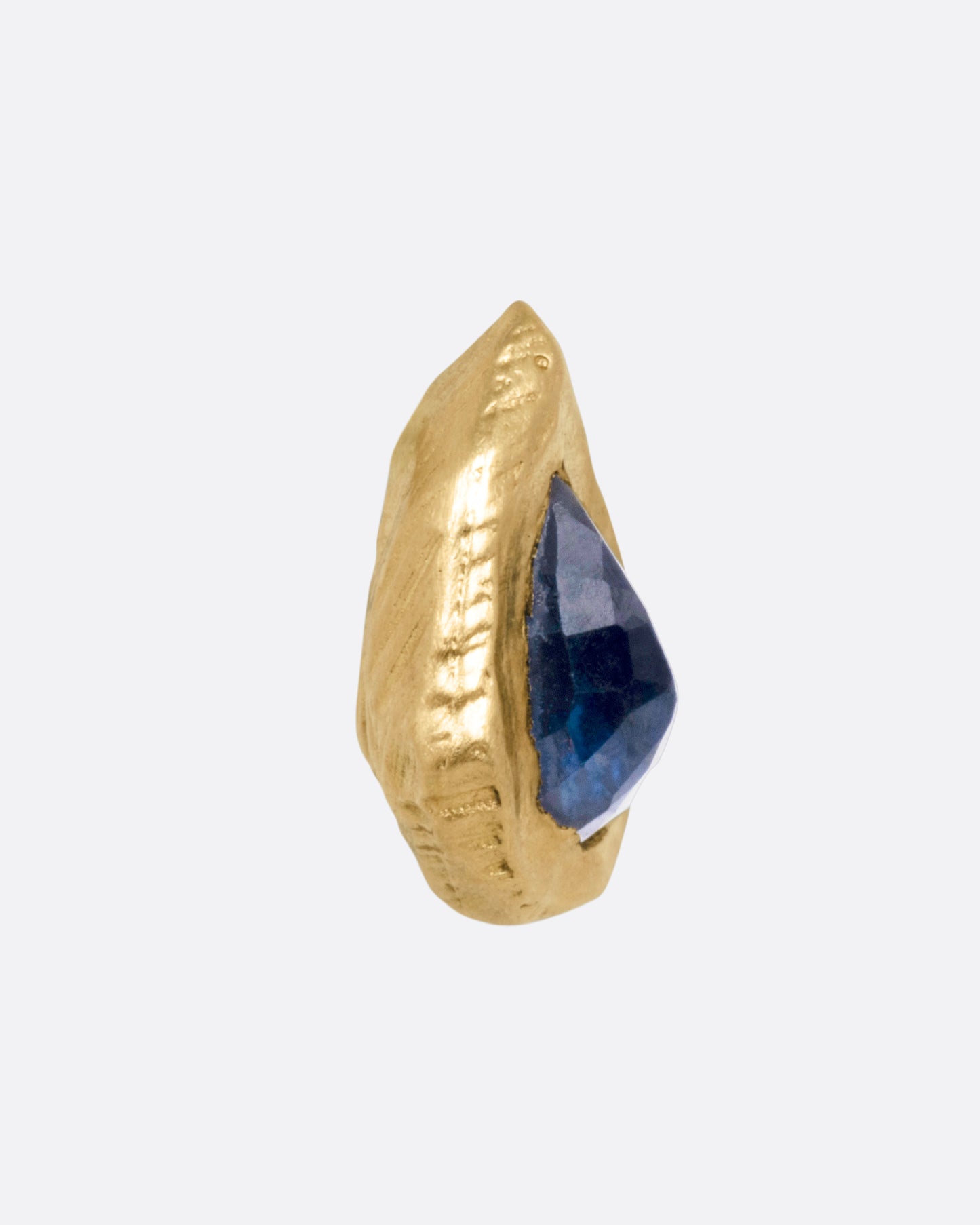A yellow gold stud earring with a teardrop shaped blue sapphire, shown from the front.