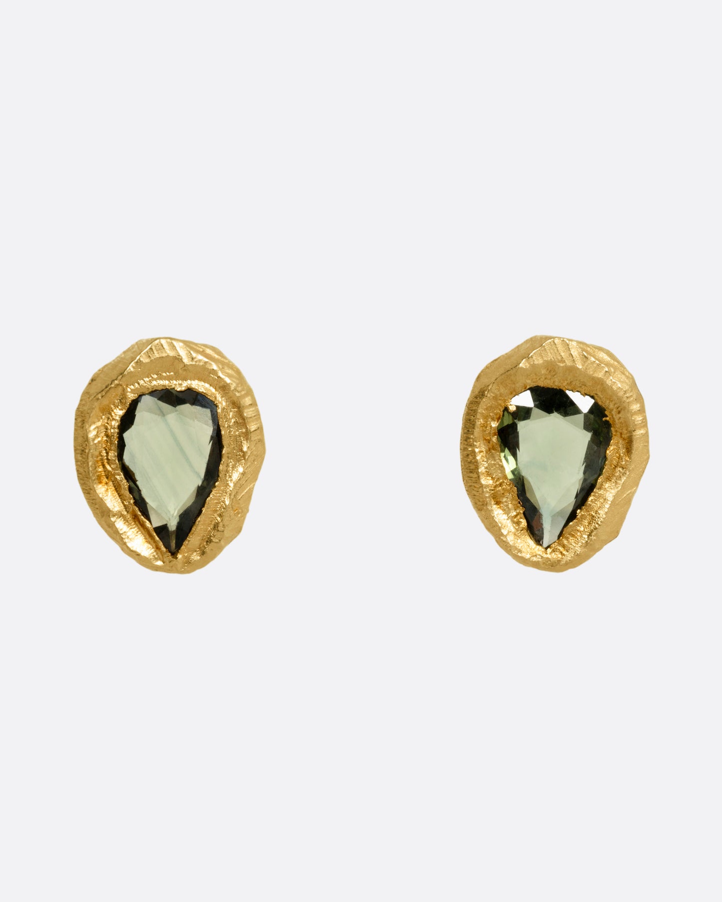 A pair of yellow gold stud earrings with teardrop shaped green sapphires, shown from the front.