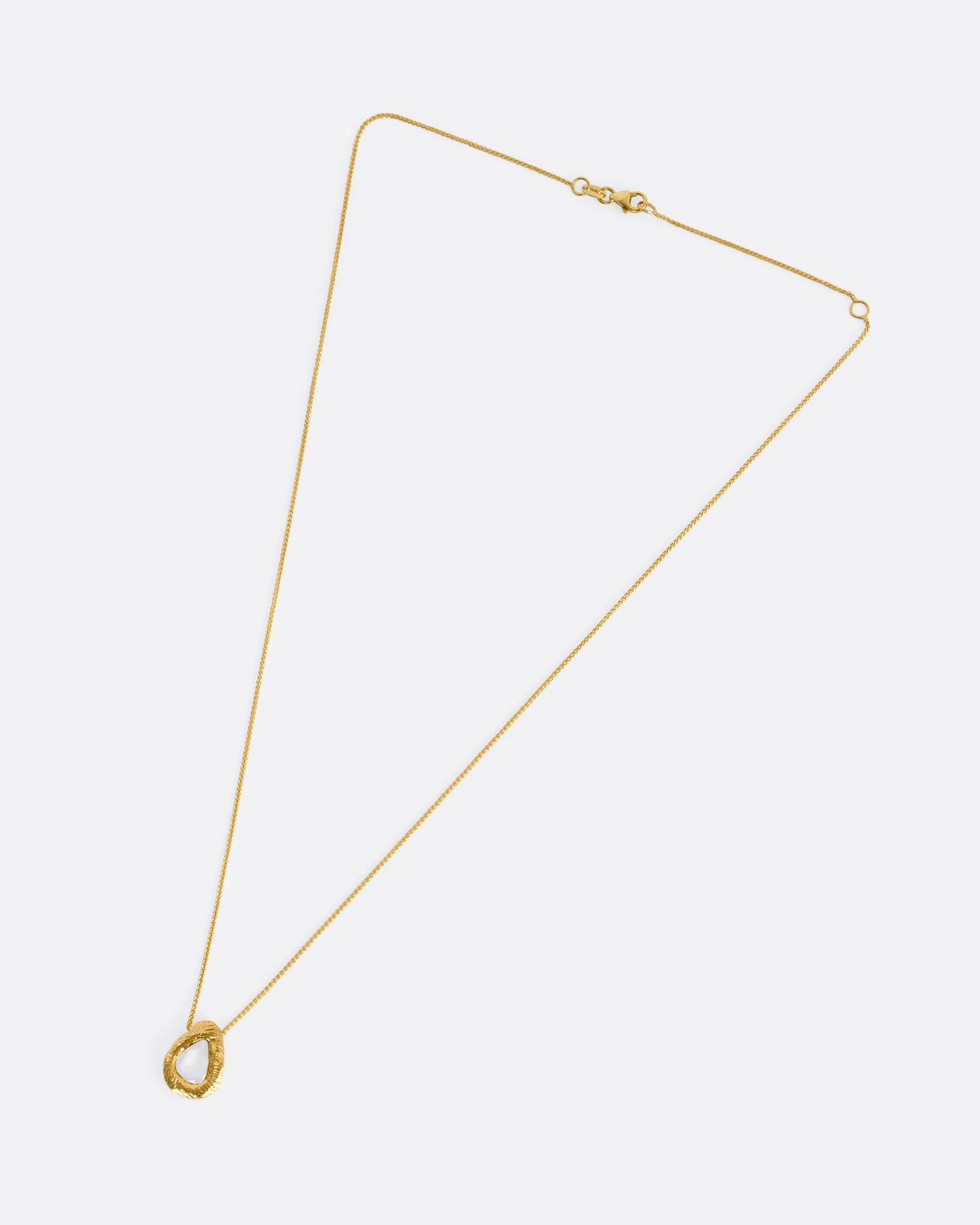 A yellow gold necklace with a yellow sapphire pendant, shown from the front.