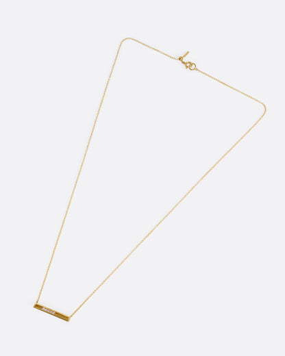 Yellow gold sliding diamond bar necklace laid flat, showing the chain length and clasp