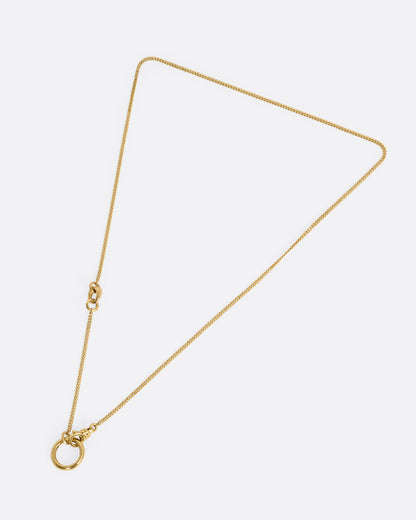 A yellow gold cable chain with an asymmetrical side bail and a central knife-edged hoop, both for charms. Shown from the front.