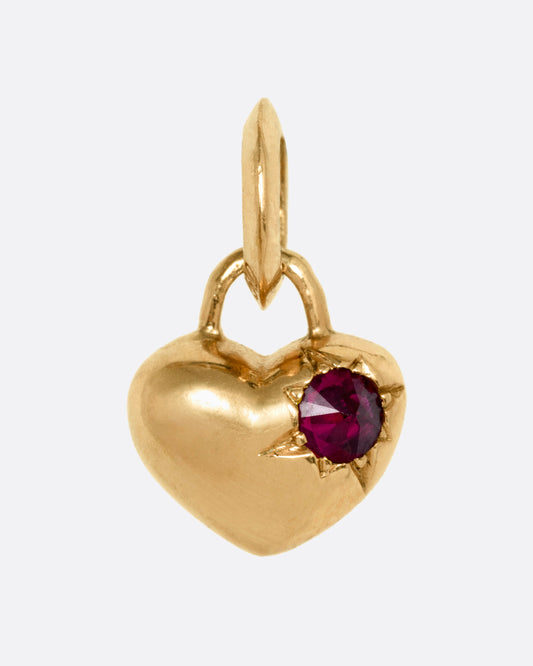 A rose gold heart charm with a reverse set ruby, shown from the front.