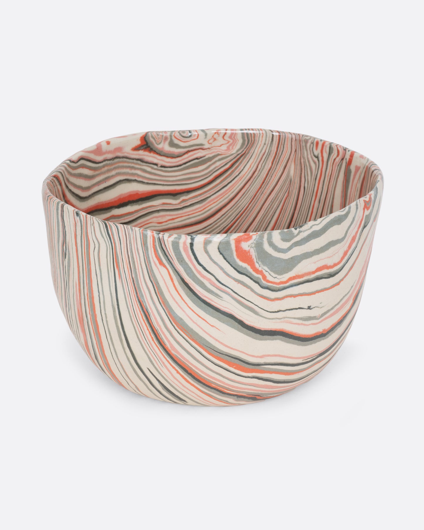A ceramic bowl with peach, gray, and cream swirls. Shown from the side.