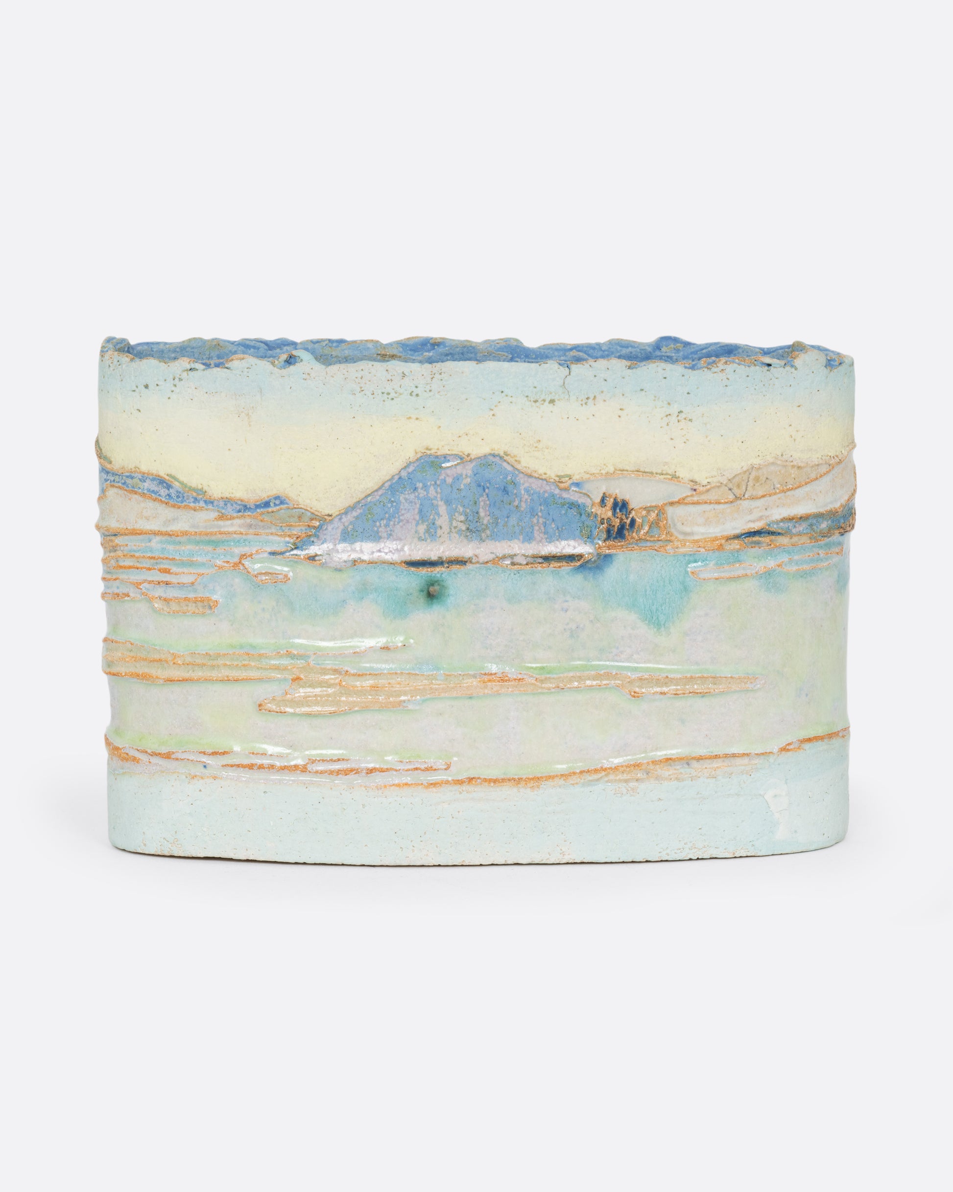 An oblong ceramic vessel with a landscape on it. Shown from the front.