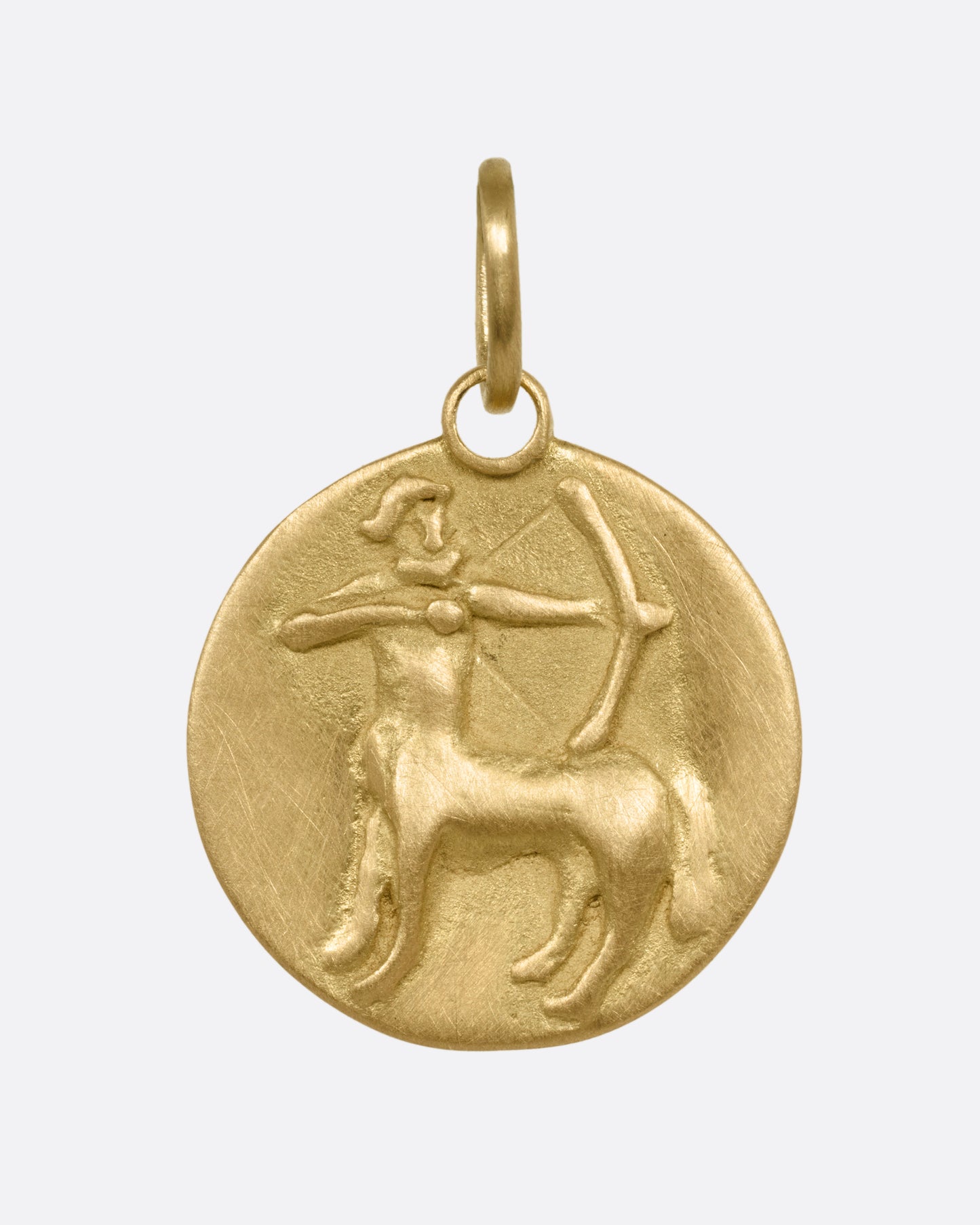 A yellow gold circular Sagittarius pendant with the archer, shown from the front.