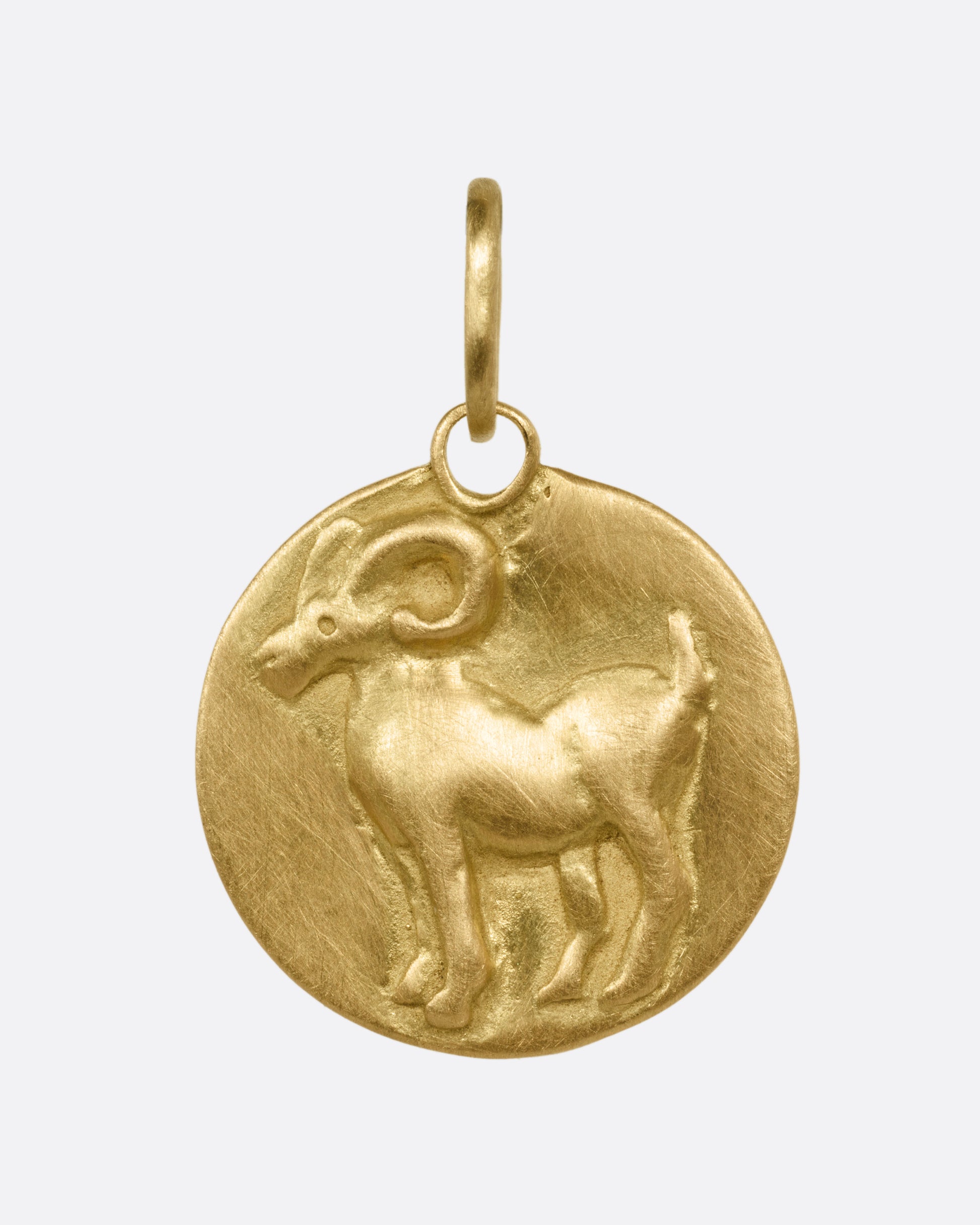 A yellow gold circular Aries pendant with a ram, shown from the front.