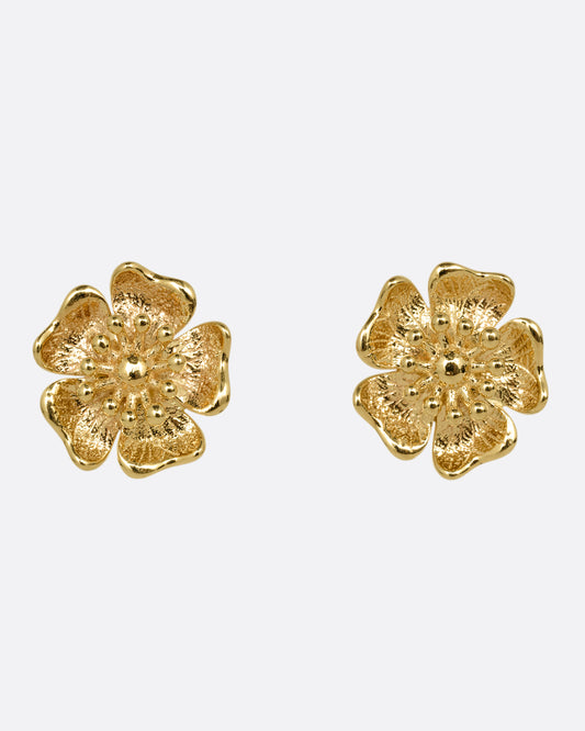 A pair of yellow gold flower stud earrings. Shown from the front.
