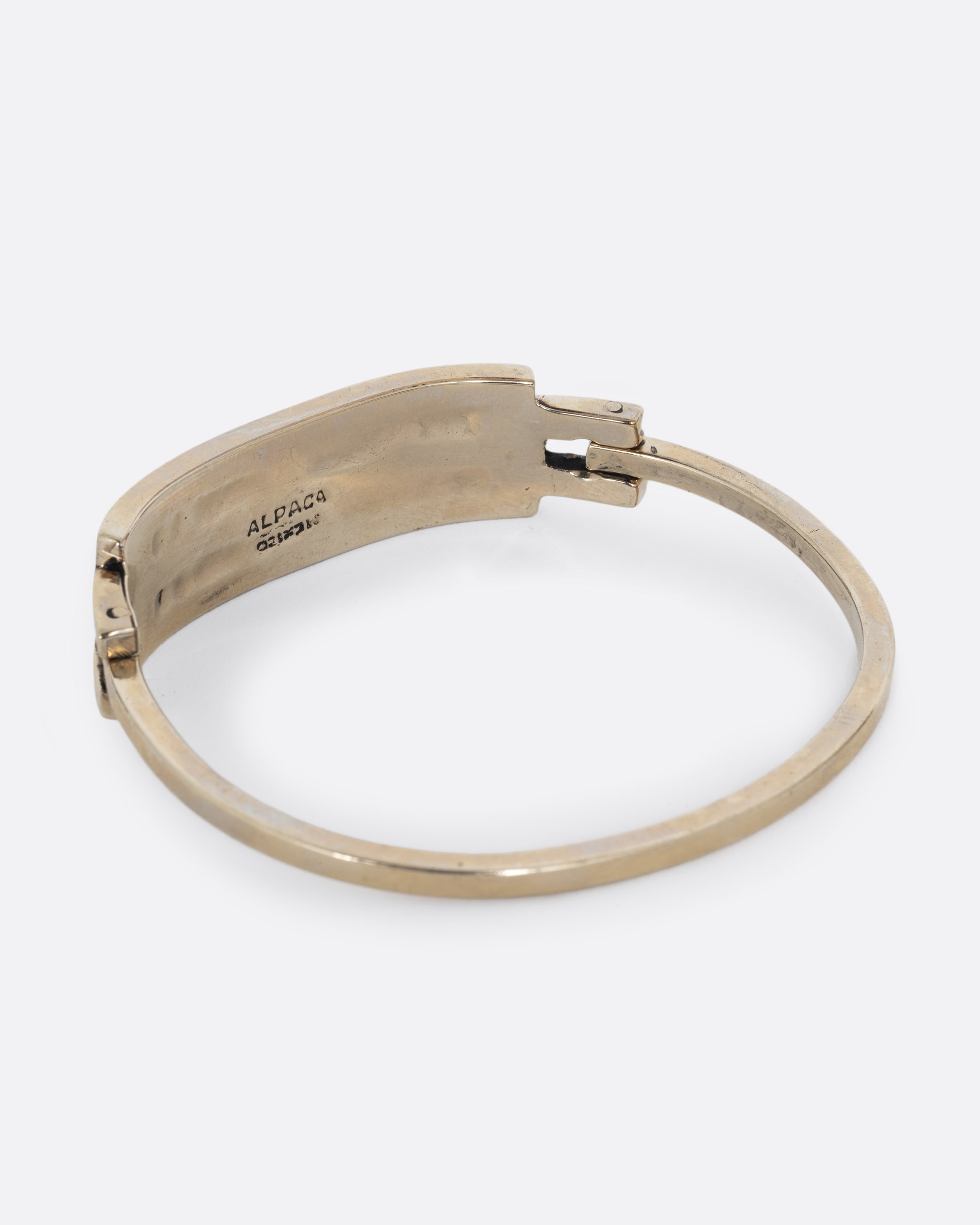 An alpaca silver bracelet with two abalone stripes and a hinged clasp. Shown from the back.