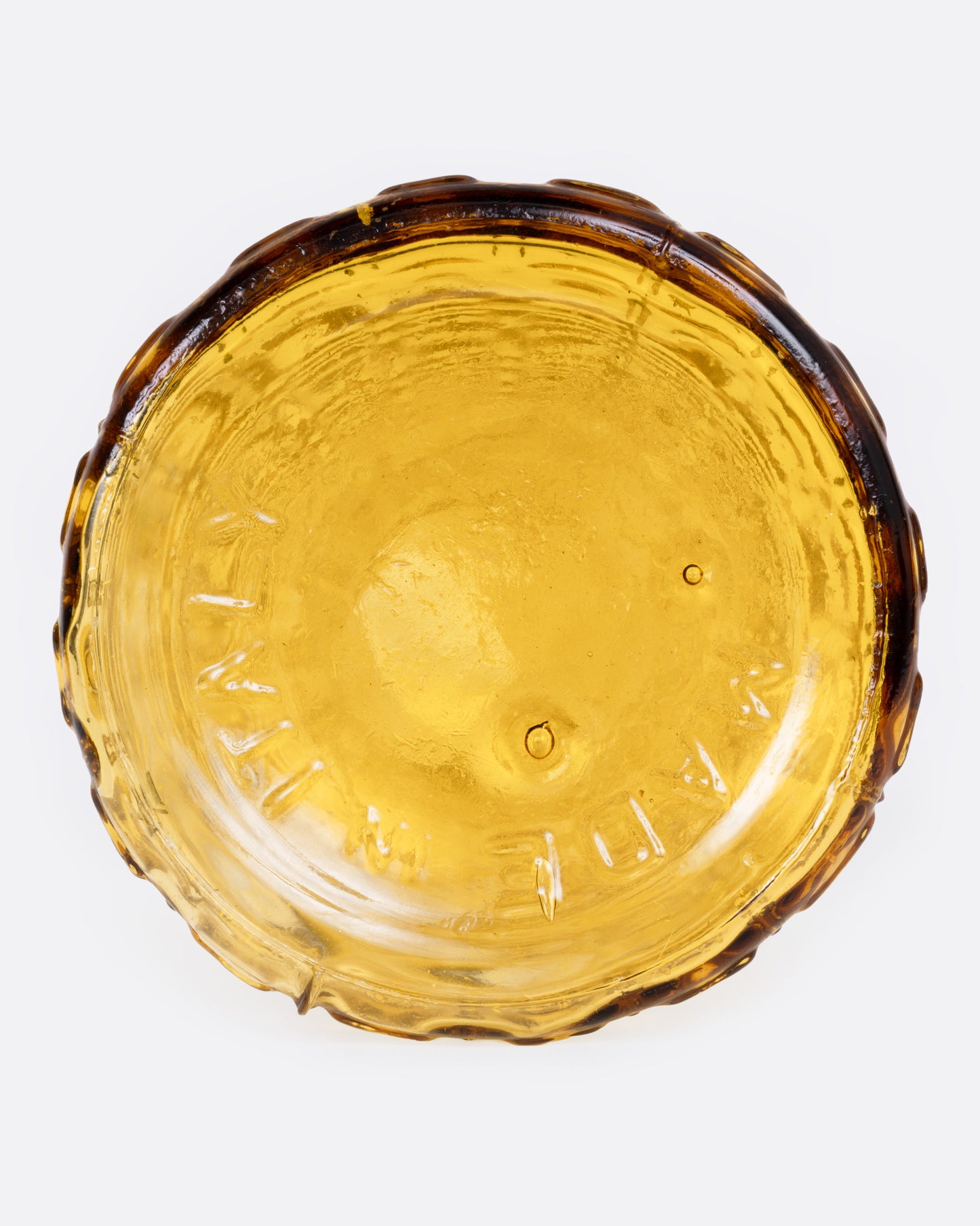 A tall tapered amber glass vase with an Aztec Hobnail exterior, shown from the bottom.