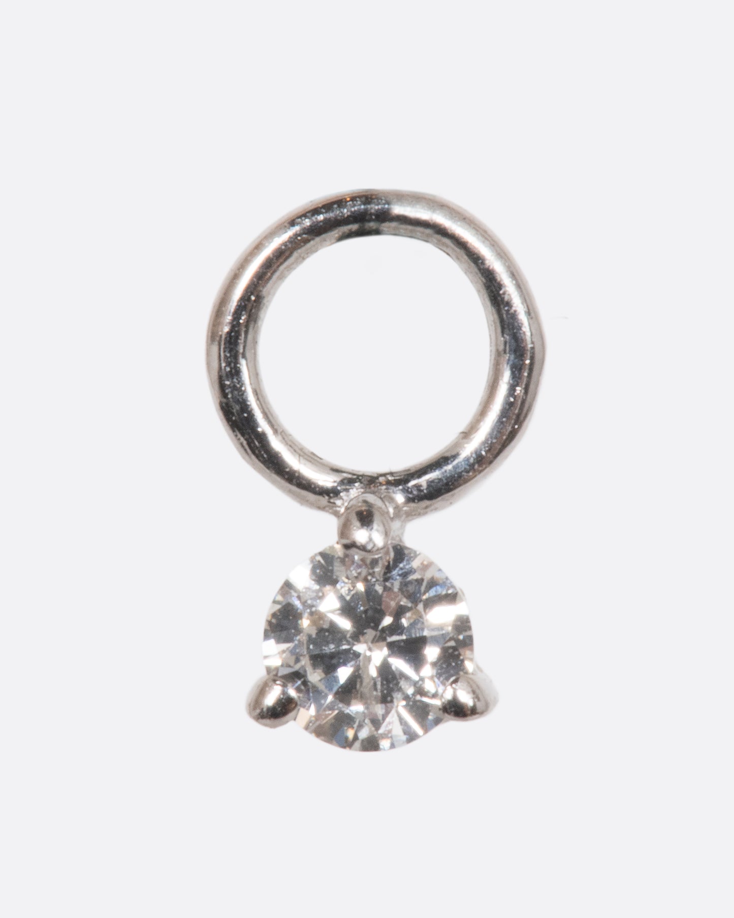 A dangle with a white gold prong setting and jump ring and a white diamond. Shown from the front.