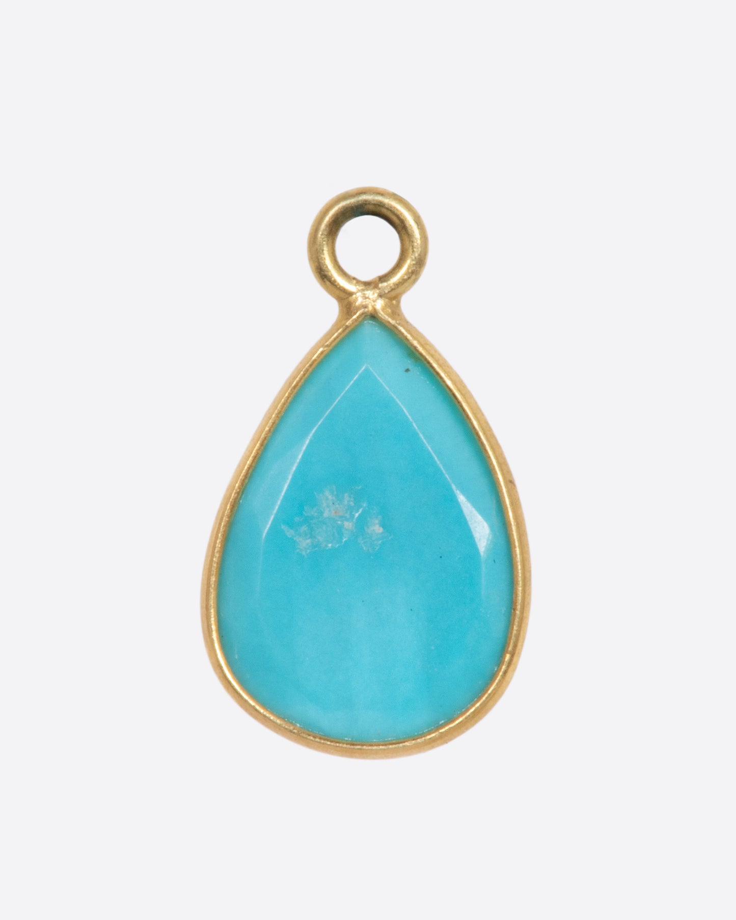 A turquoise teardrop shaped dangle set in yellow gold with a yellow gold bail. Shown from the back.