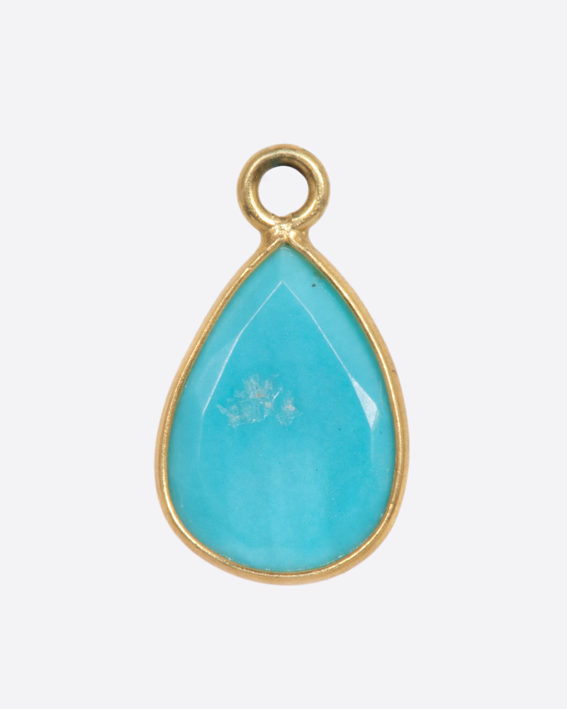 A turquoise teardrop shaped dangle set in yellow gold with a yellow gold bail. Shown from the back.
