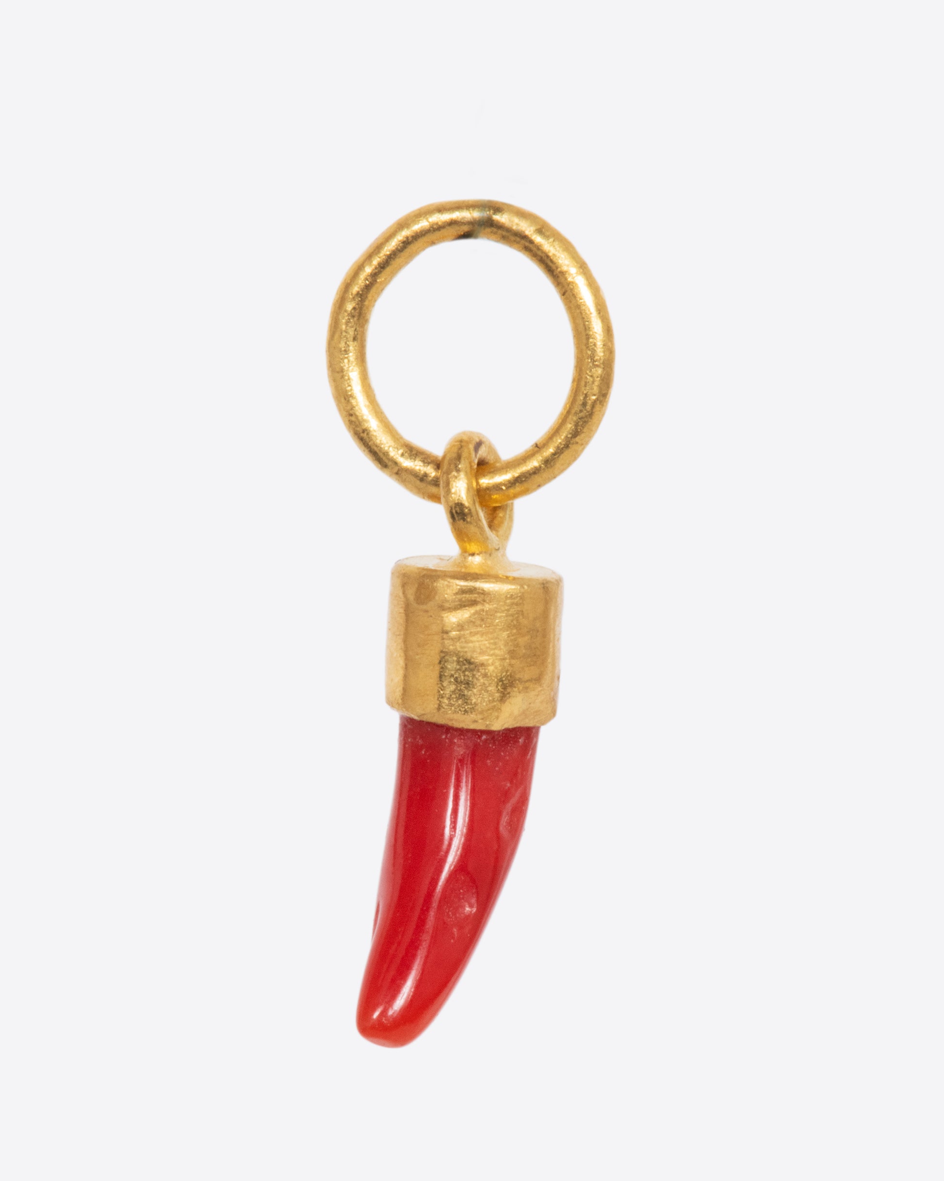 A coral Italian horn dangle with a yellow gold bail and jump ring. Shown from the side.