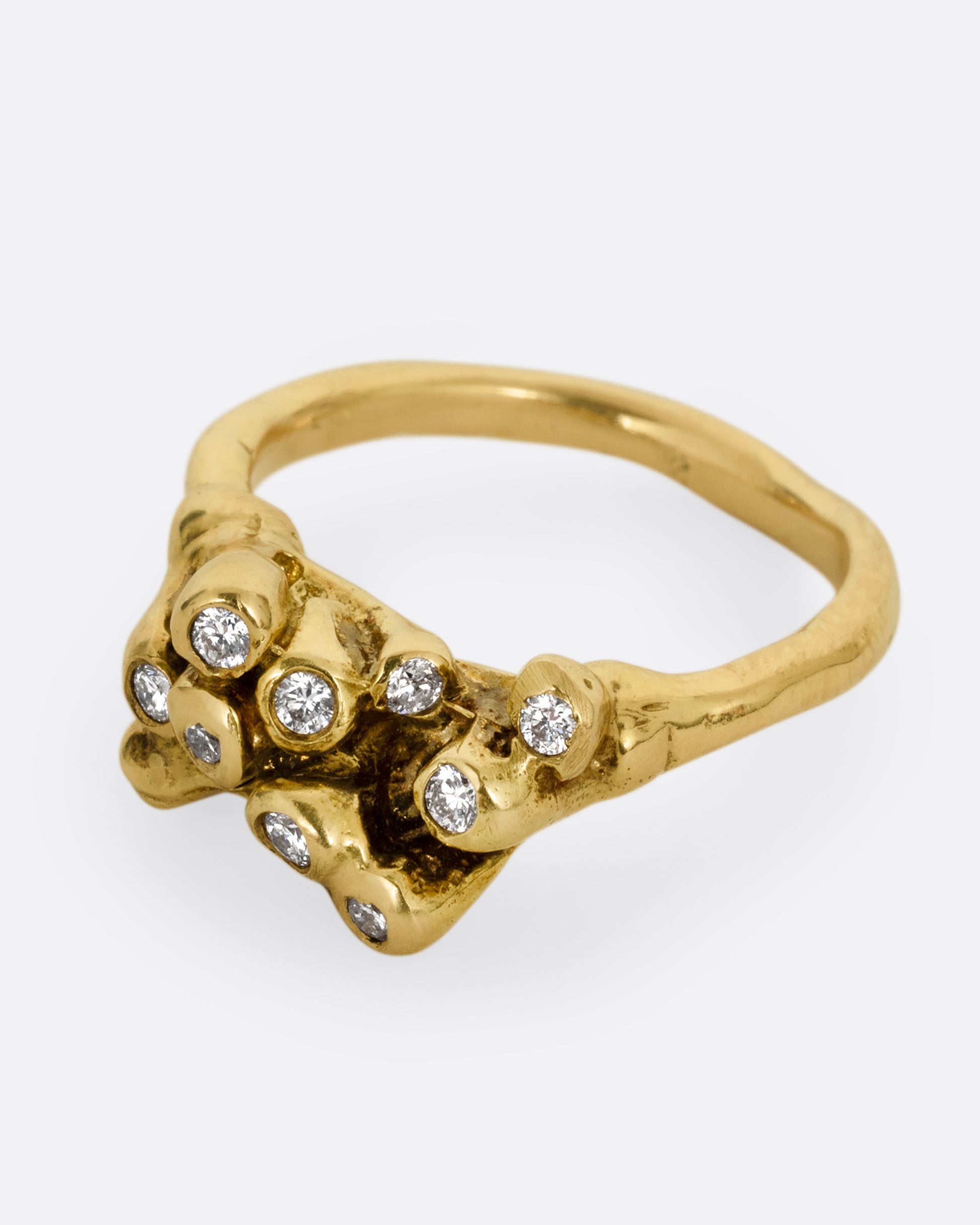 A yellow gold ring with diamond tipped anemones. Shown from the side.