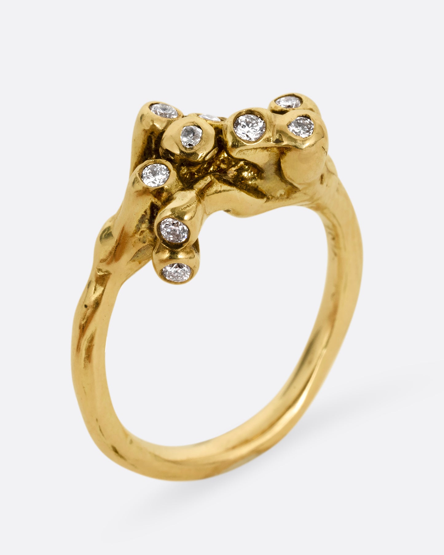 A yellow gold ring with diamond tipped anemones. Shown standing up from the side.