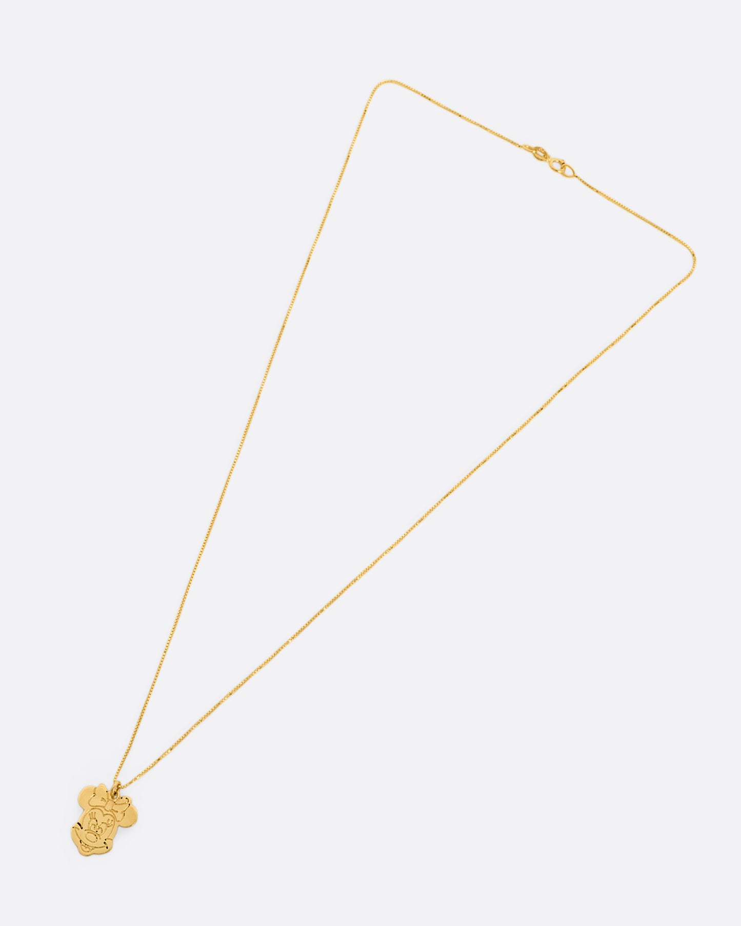 Yellow gold Minnie Mouse pendant hanging from box chain. View from above, laying flat.