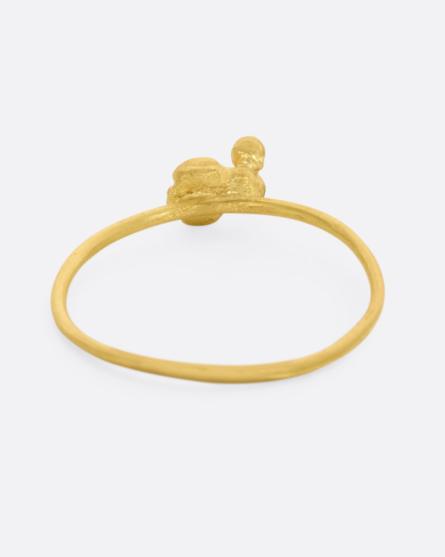 A yellow gold featuring a tiny bug with diamond eyes on a dainty band. View from the back.