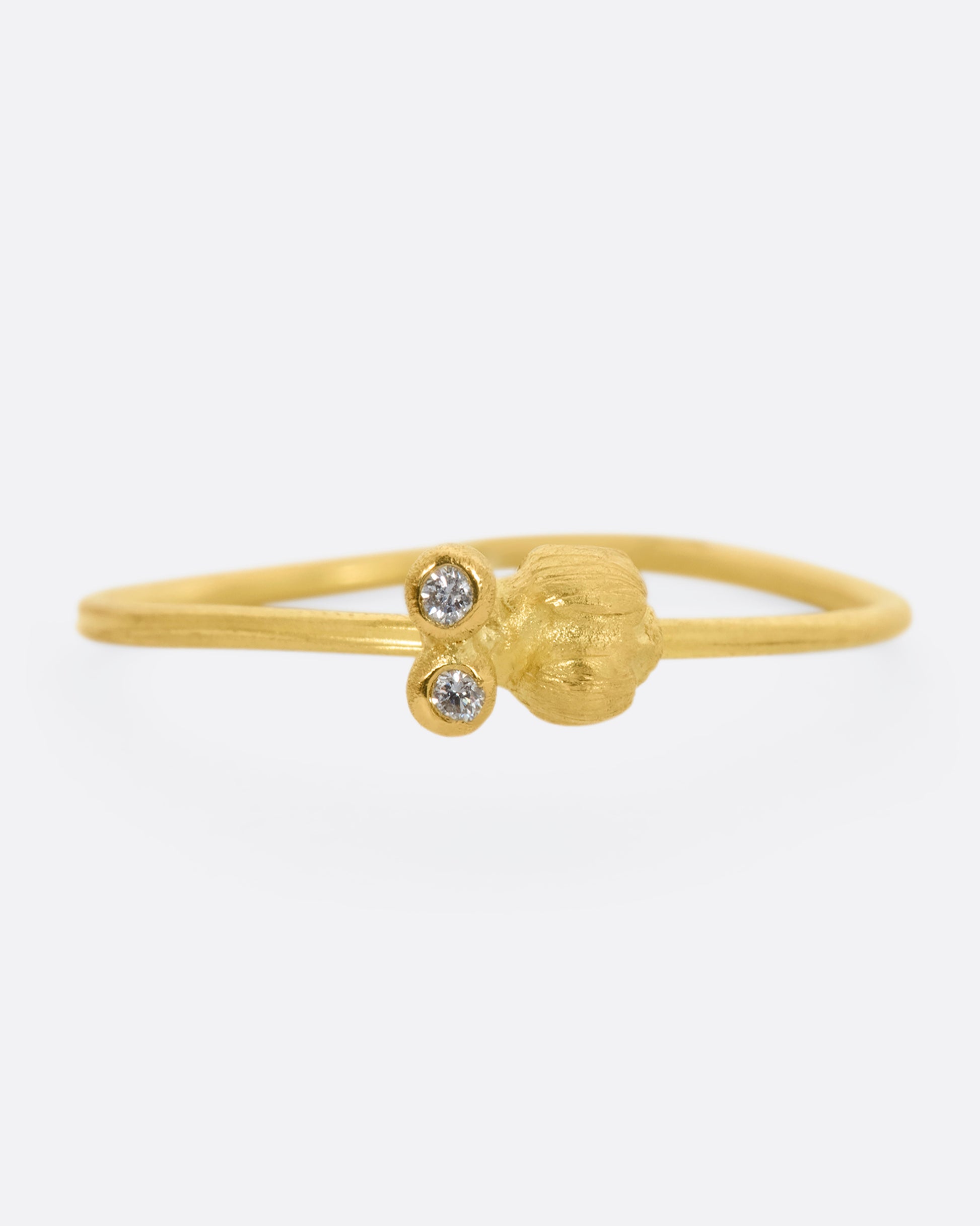 A yellow gold featuring a tiny bug with diamond eyes on a dainty band. View from the front.