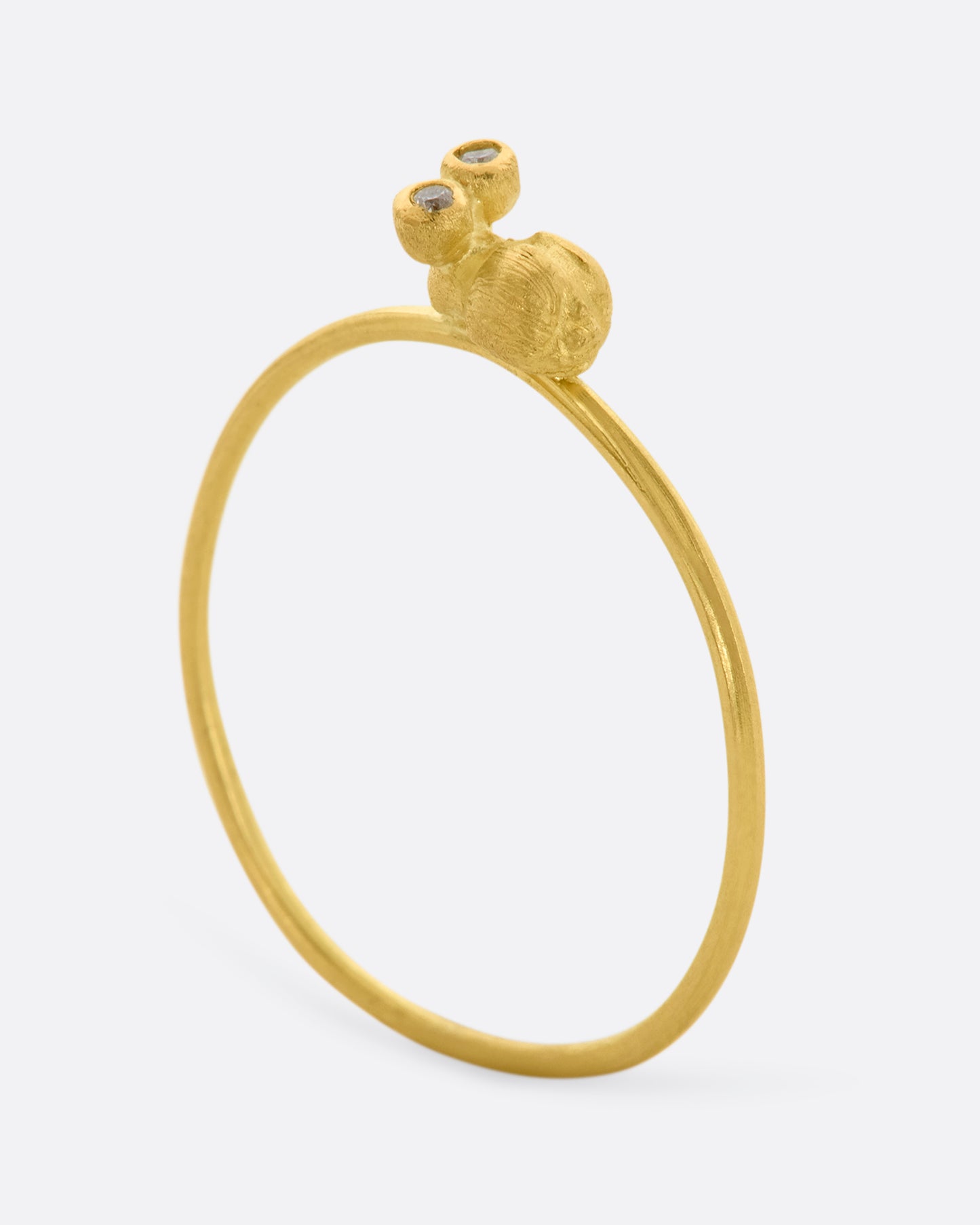 A yellow gold featuring a tiny bug with diamond eyes on a dainty band. View standing.