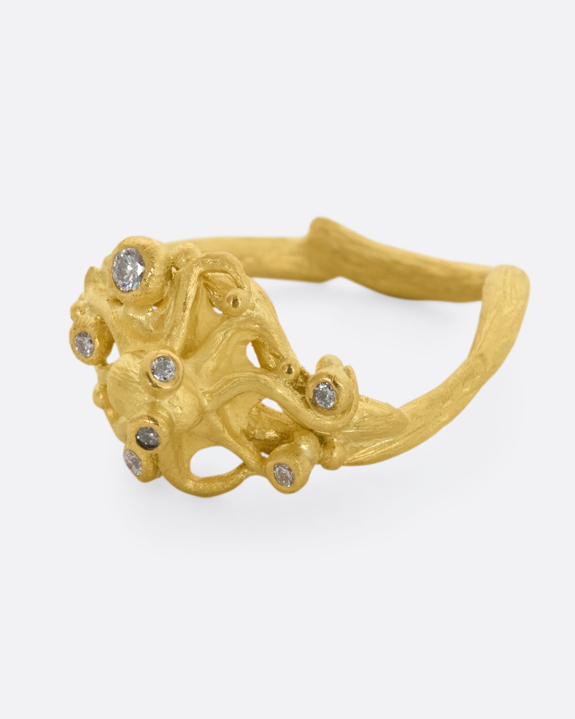 A yellow gold ring featuring an octopus with diamond eyes, surrounded by diamonds. View from the left side.