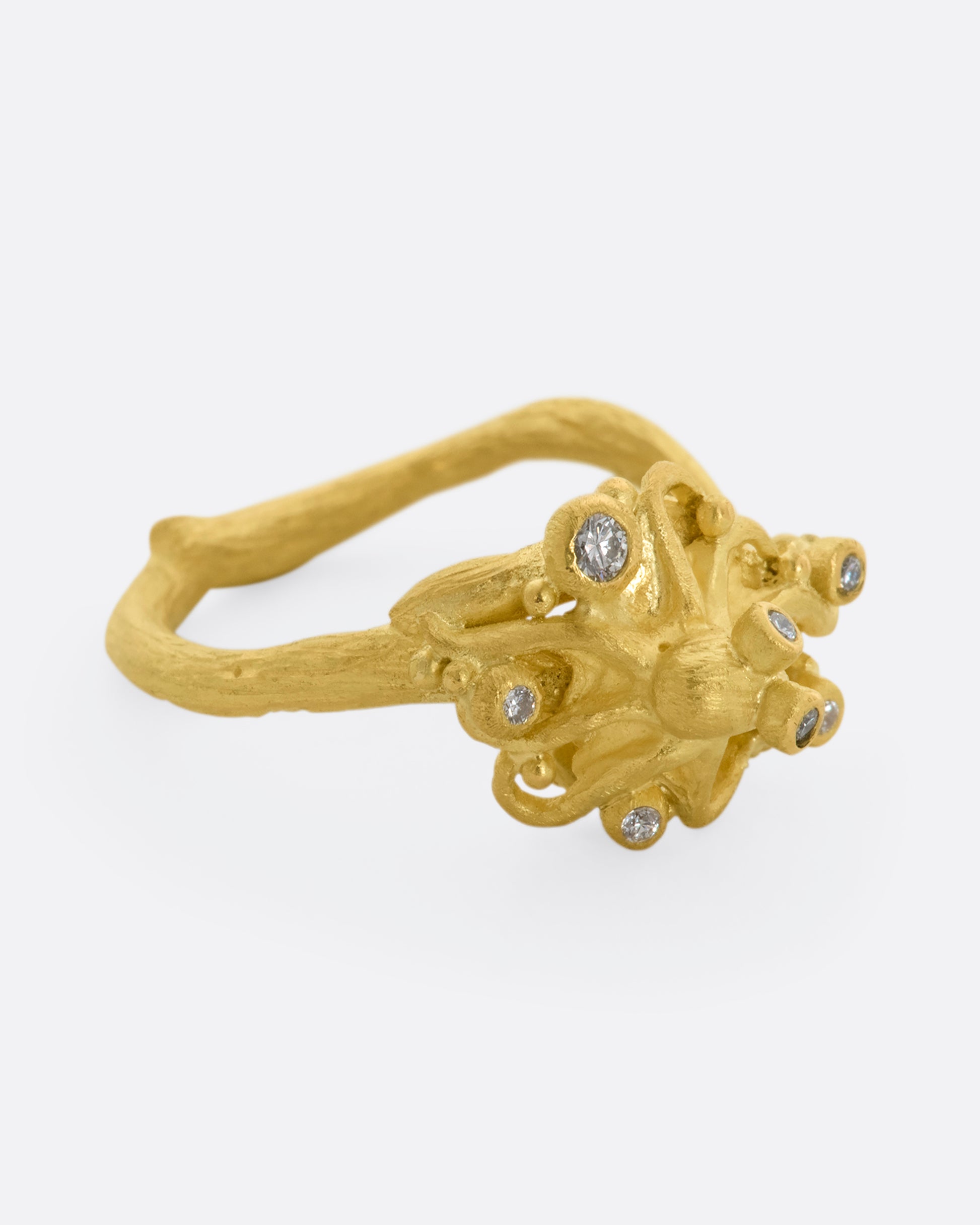 A yellow gold ring featuring an octopus with diamond eyes, surrounded by diamonds. View from the right side.