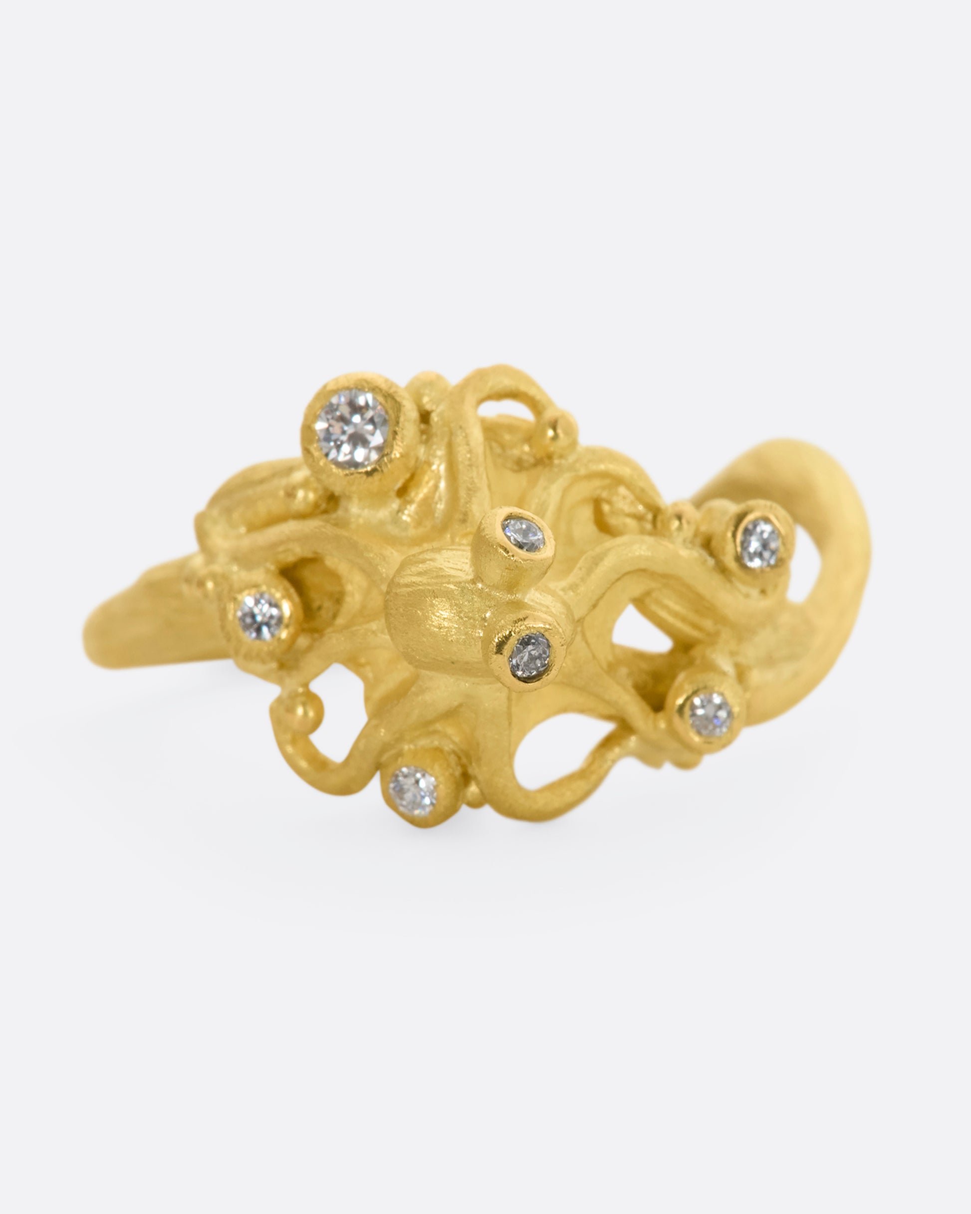 A yellow gold ring featuring an octopus with diamond eyes, surrounded by diamonds. View from the front. 