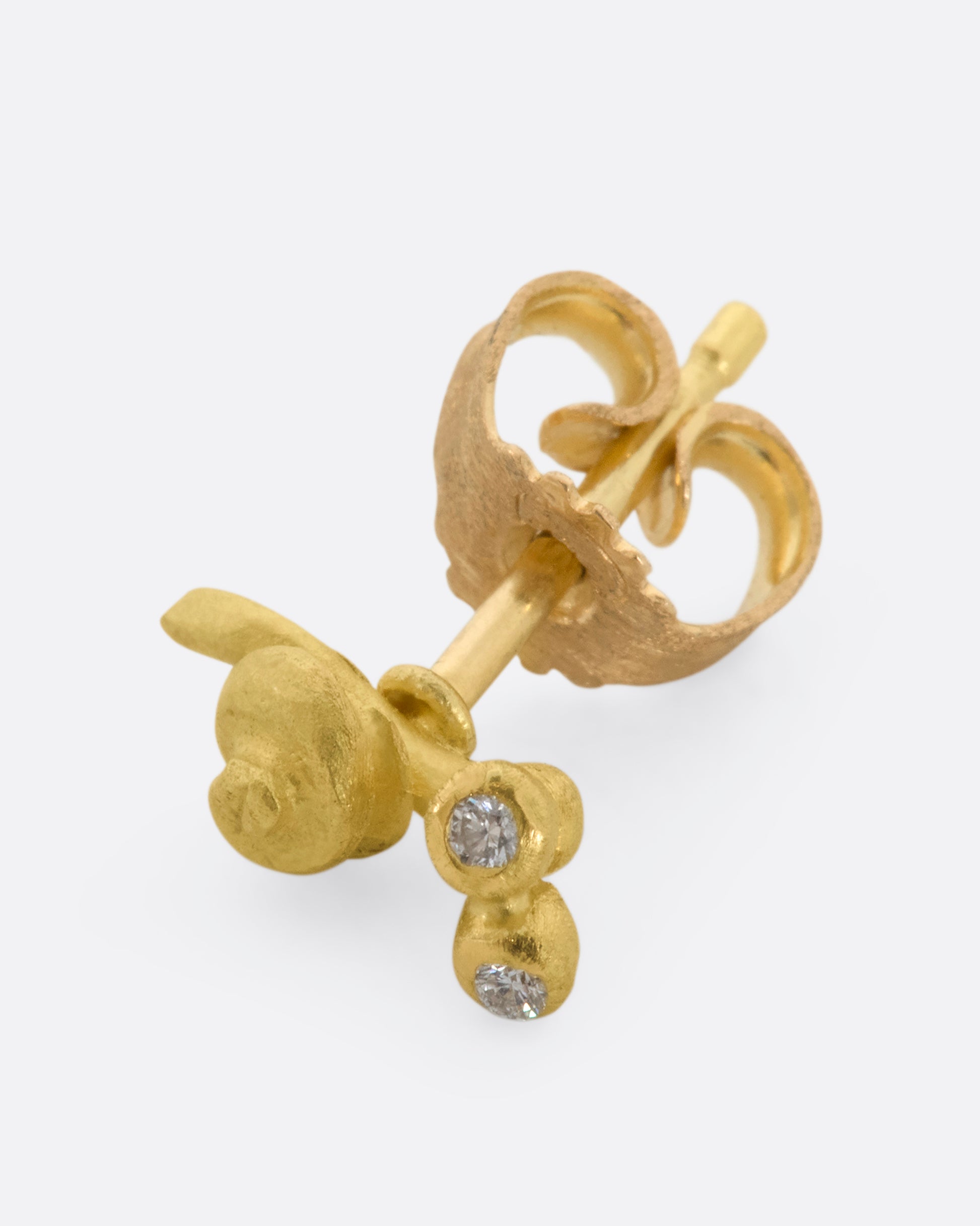 A yellow gold snail earrig with diamond eyes. View from the side.