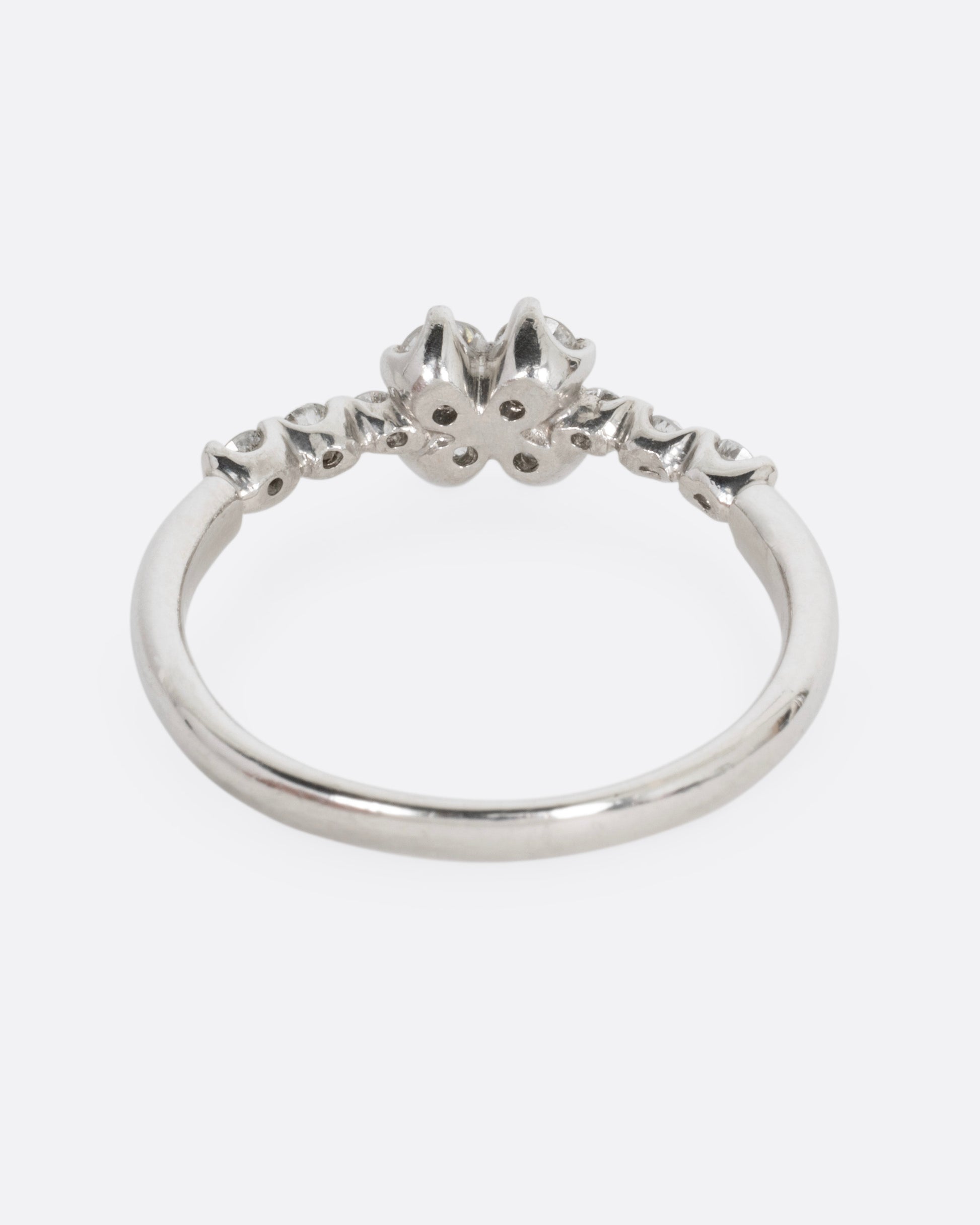 A platinum ring with an 'X' shape and diamonds, shown from the back.