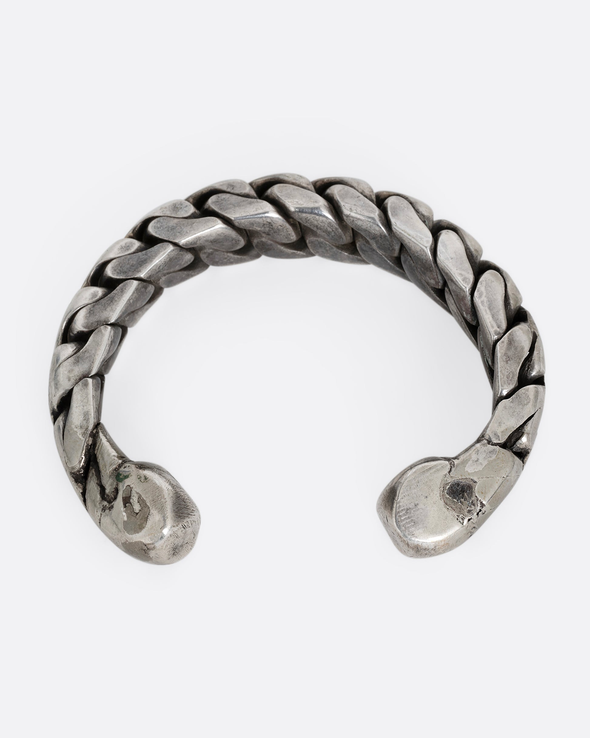 A silver curb chain cuff bracelet, soldered stiff with an open back. Shown from the back.