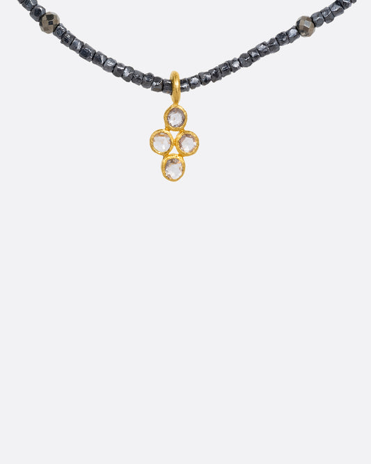 A pyrite bead necklace with a diamond quartet charm at the center. Shown from the front.