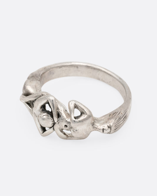 A silver ring with an erotic couple. Shown from the front.