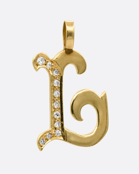 A yellow gold curly letter L pendant with a column of white diamonds. Shown from the front.