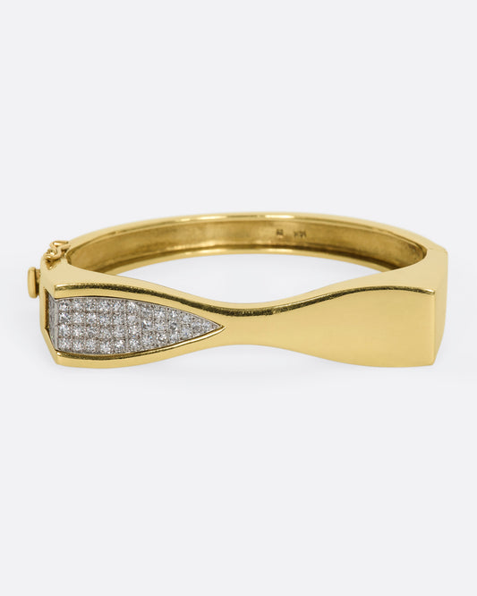 Yellow gold hinged bracelet with pave diamond section on half of the face. View from the front.