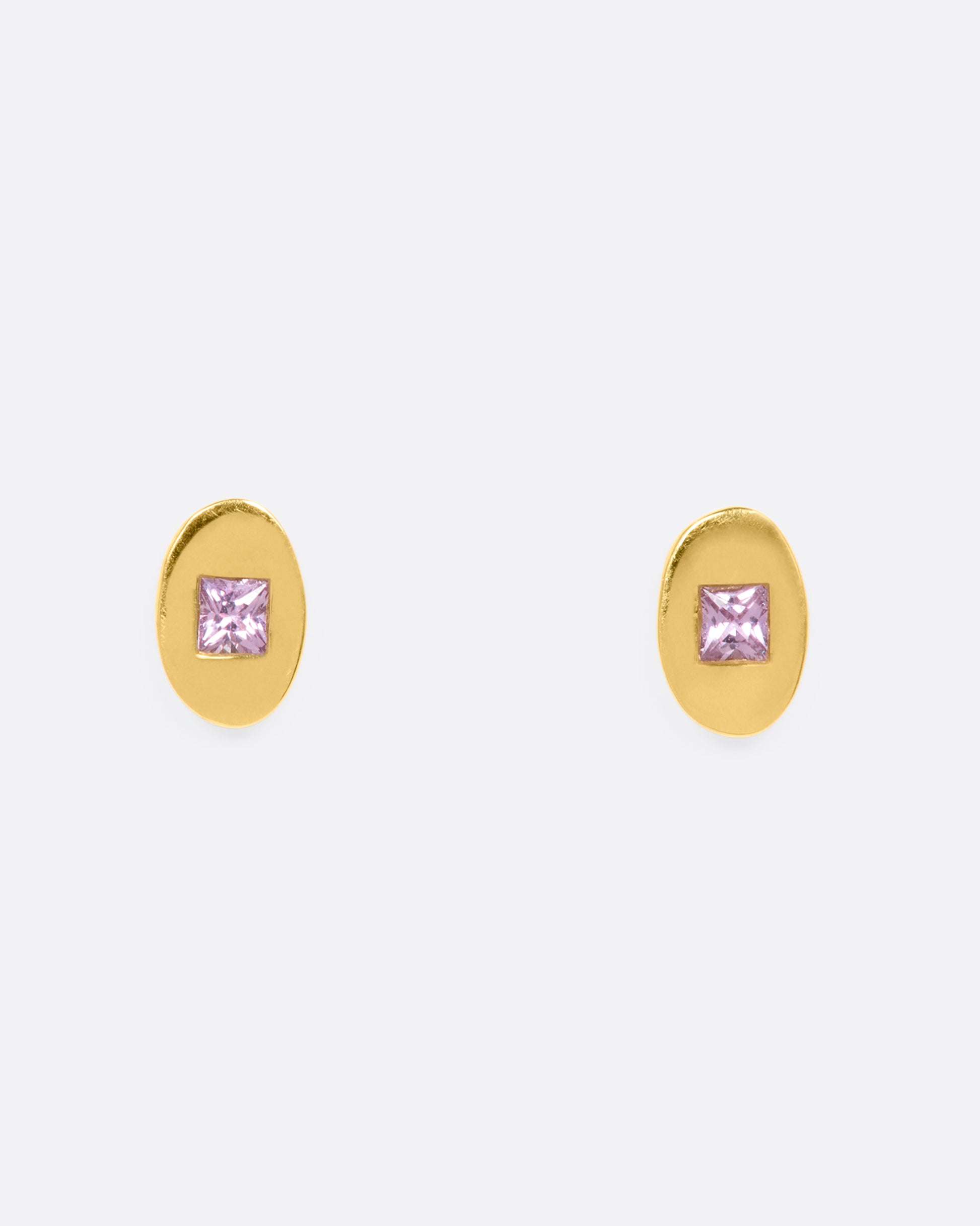 Yellow gold oval studs with princess cut pink sapphires. View from the front.