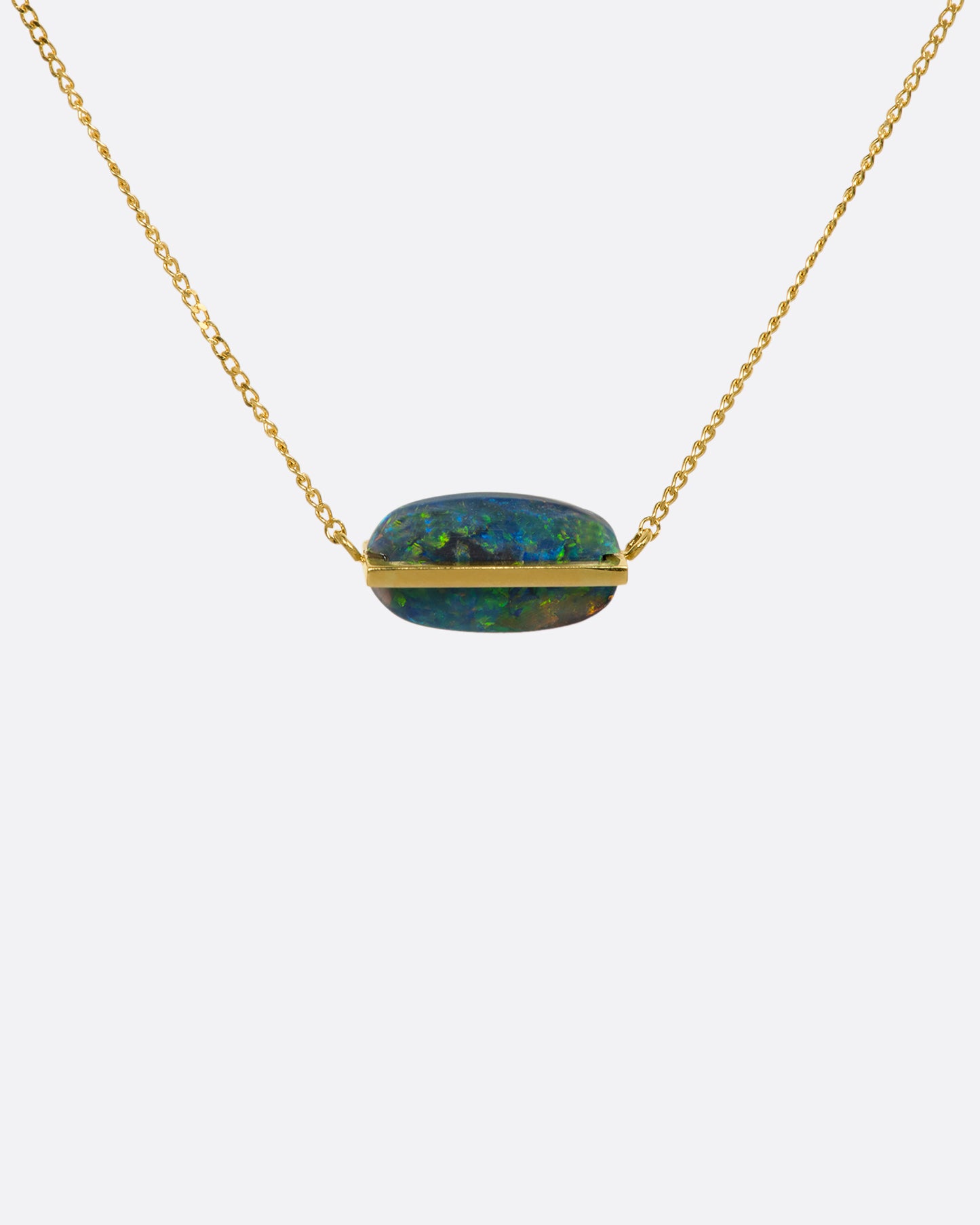 A yellow gold necklace with an oval black opal. View up close from the front.