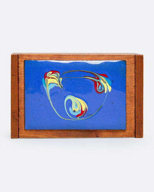A colorful abstract enamel top on a wooden box, shown from the top.
