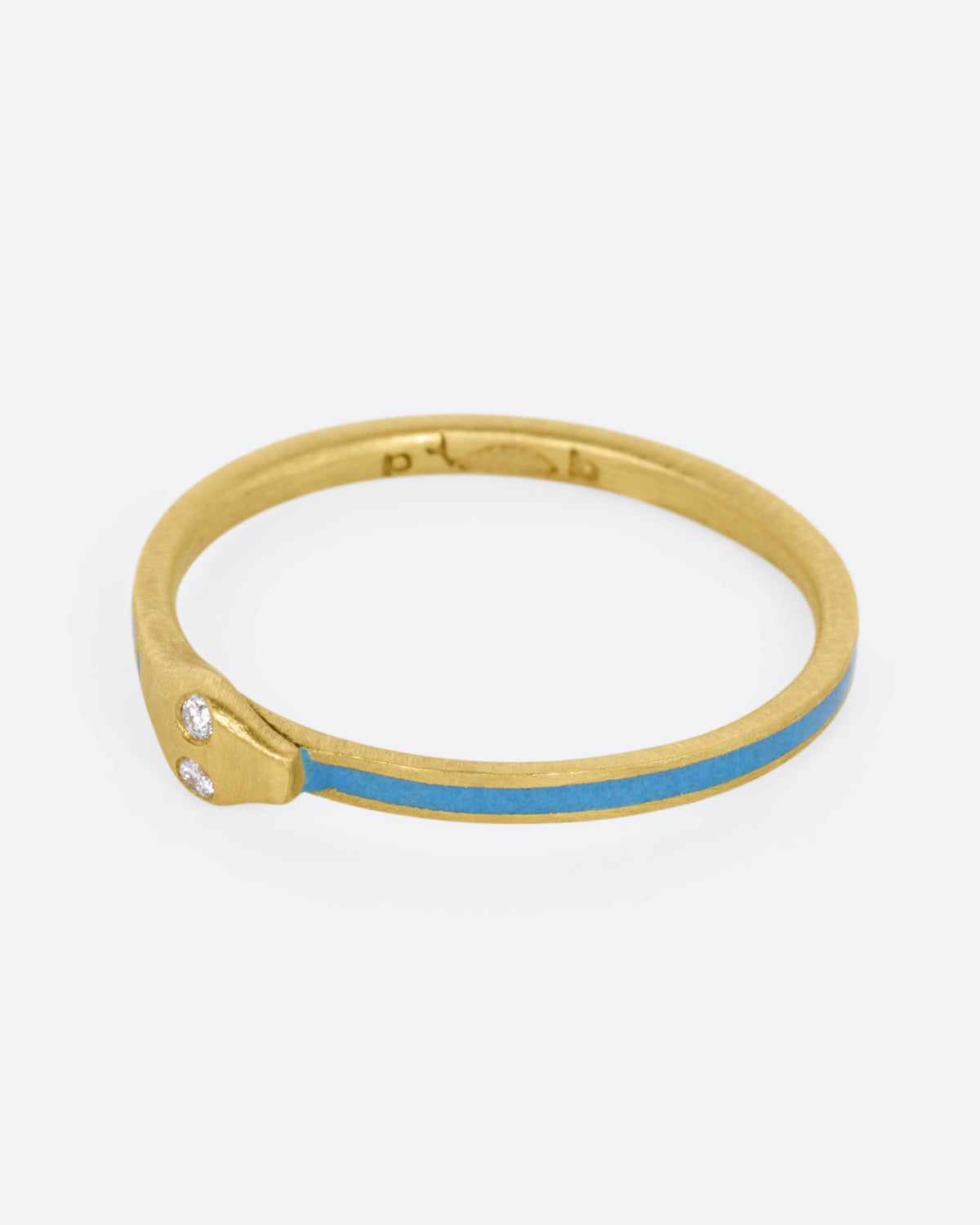 A yellow gold ouroboros ring with diamond eyes and pale blue enamel, shown from the side. 