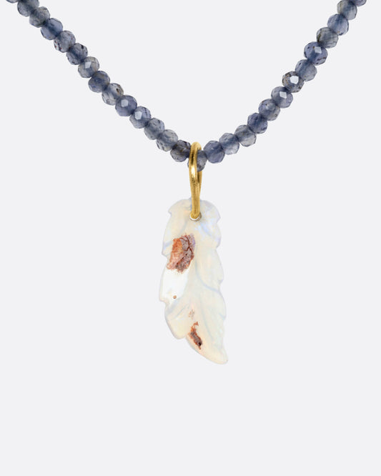 A beaded iolite necklace with a handcarved opal leaf pendant, shown from the front.