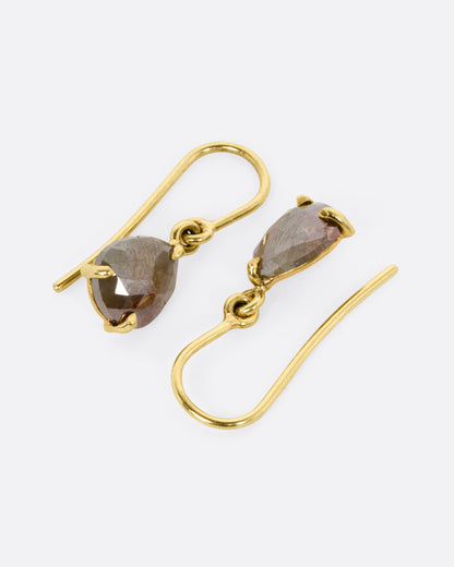 A pair of yellow gold drop earrings with olive diamonds, shown from the side.