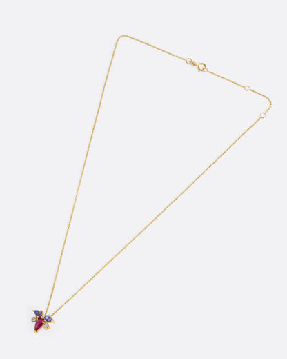 A yellow gold necklace with a muska fly pendant with a pink tourmaline thorax and blue tourmaline and diamond wings, shown from the front.