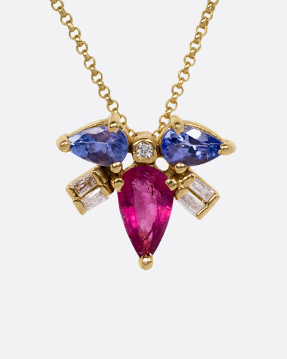 A yellow gold necklace with a muska fly pendant with a pink tourmaline thorax and blue tourmaline and diamond wings, shown from the front.